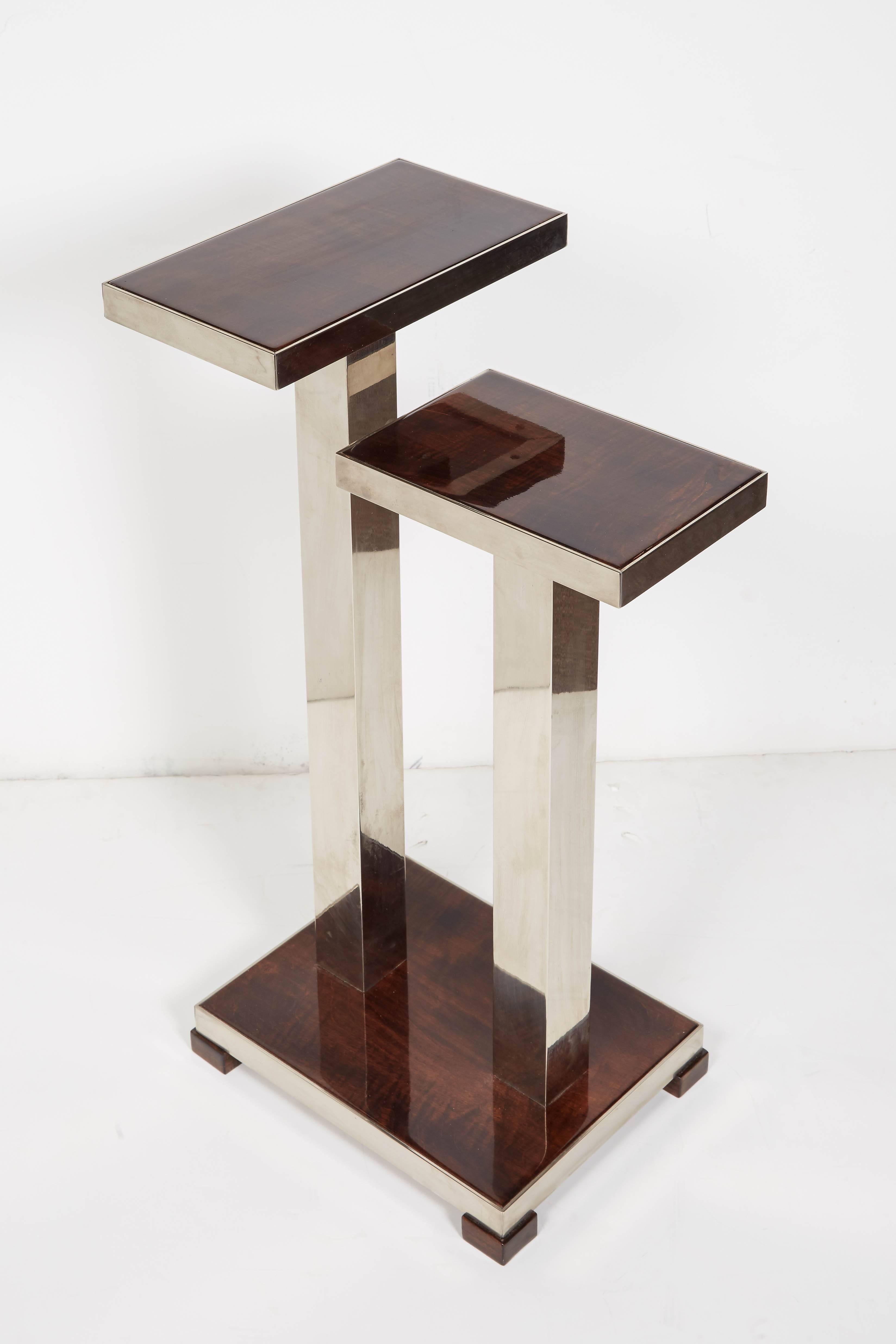 French modernist rectangular, two-tier table with nickeled bronze double tubular base. Architectural in design with cubist lines, this asymmetrical table with shelves at varied heights is fully armored with polished nickeled bronze banding. The