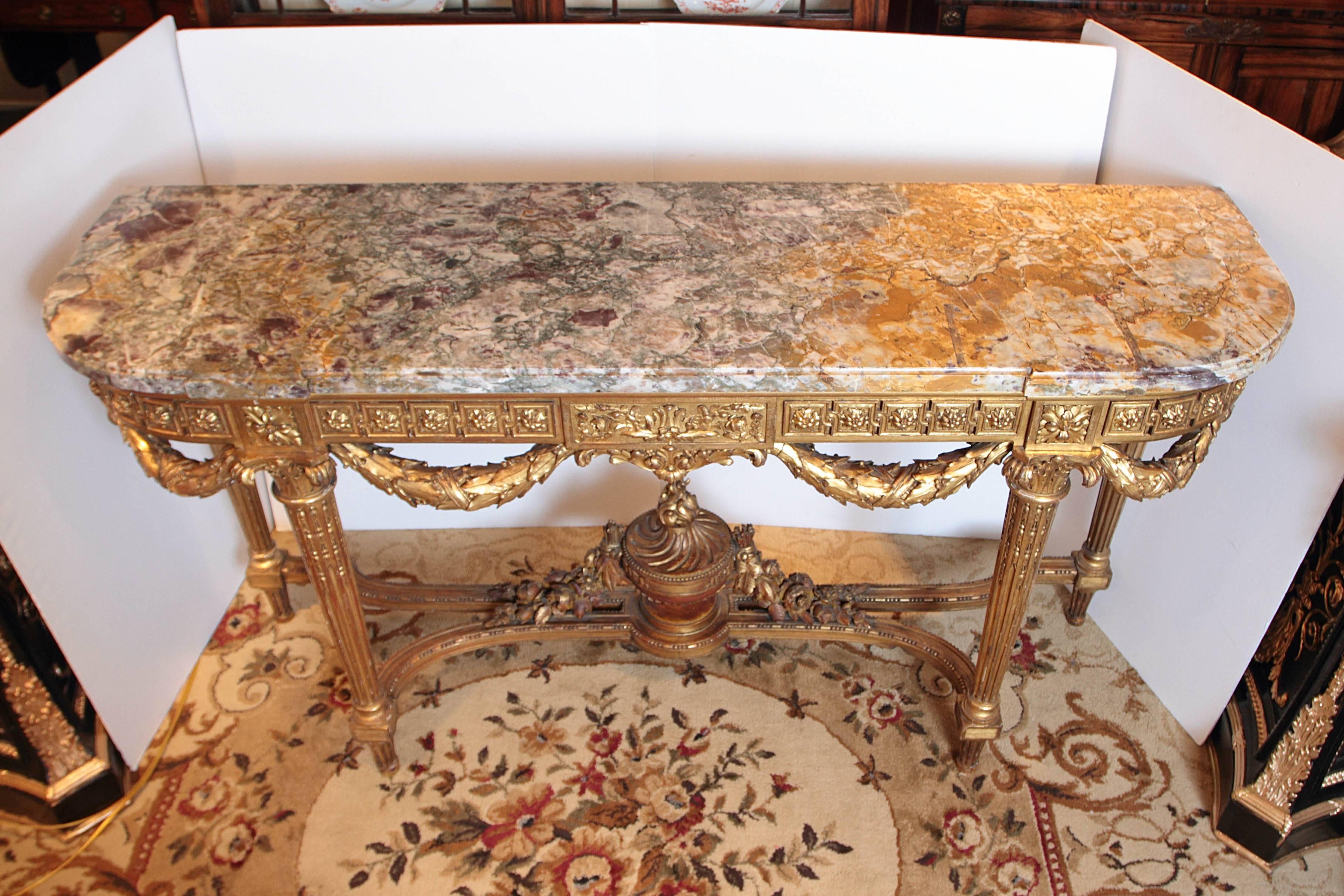 Finely detailed and carved Louis XVI gilt marble top console. Carved with swag and urn detail.