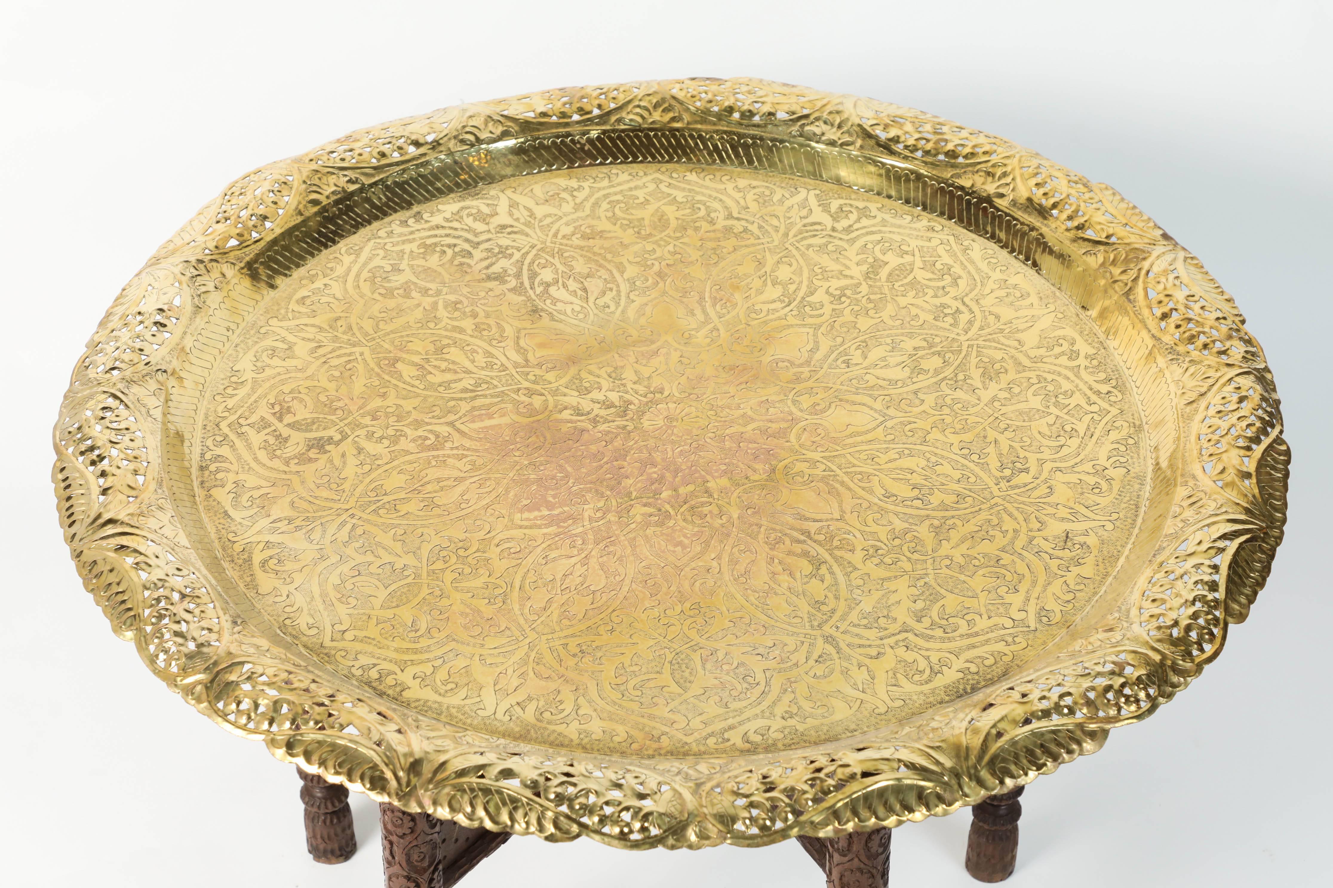 Anglo-Indian engraved and embossed large round polished brass tray coffee table.
Polished Middle Eastern style brass tray, standing on folding wooden base with six legs.
Large Moorish style hand-hammered brass tray table, Middle Eastern, Moorish