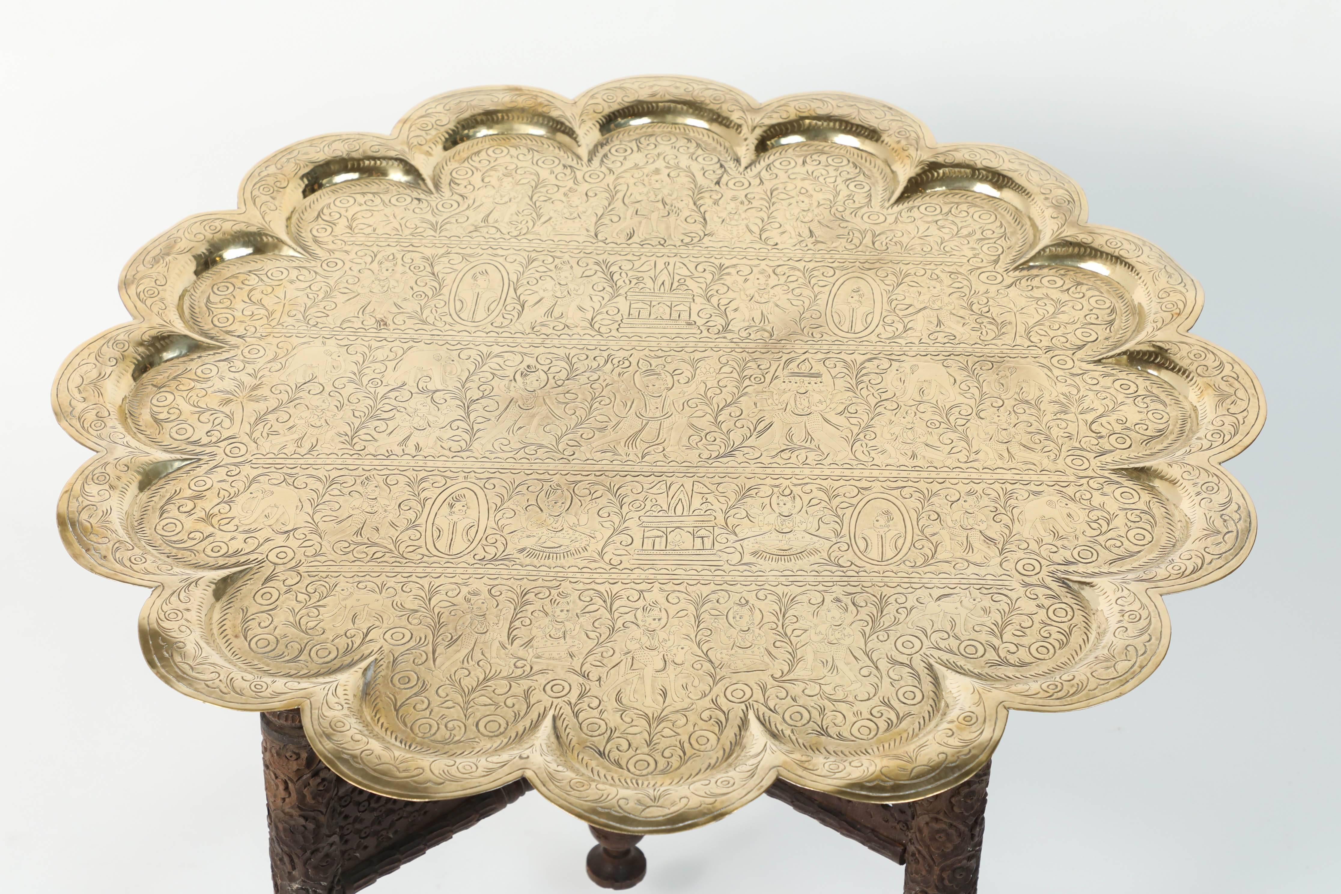 Anglo Indian engraved and embossed round polished gold brass tray table.
Polished Middle Eastern style brass tray standing on folding handcrafted wooden base with four legs.
Very hard to find Moorish design hand-hammered brass tray finely