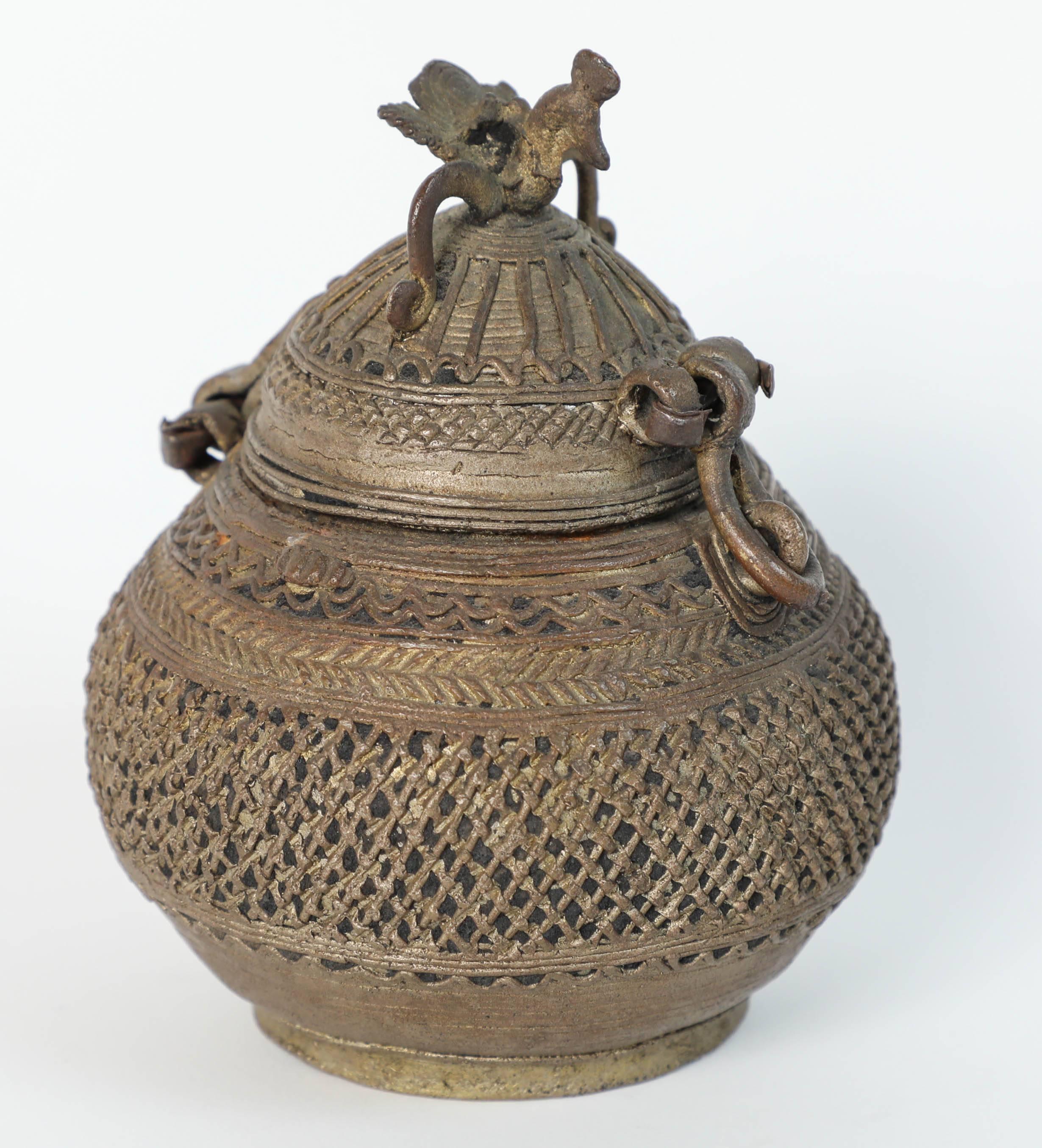An extraordinary tribal India bronze censor box.
Constructed as a cage made from many rolled wax wires in an organic swollen mango form, with a hinged lid surmounted by a stylized peacock exotic bird finial.
Tribal India bronze censor box. Kondh