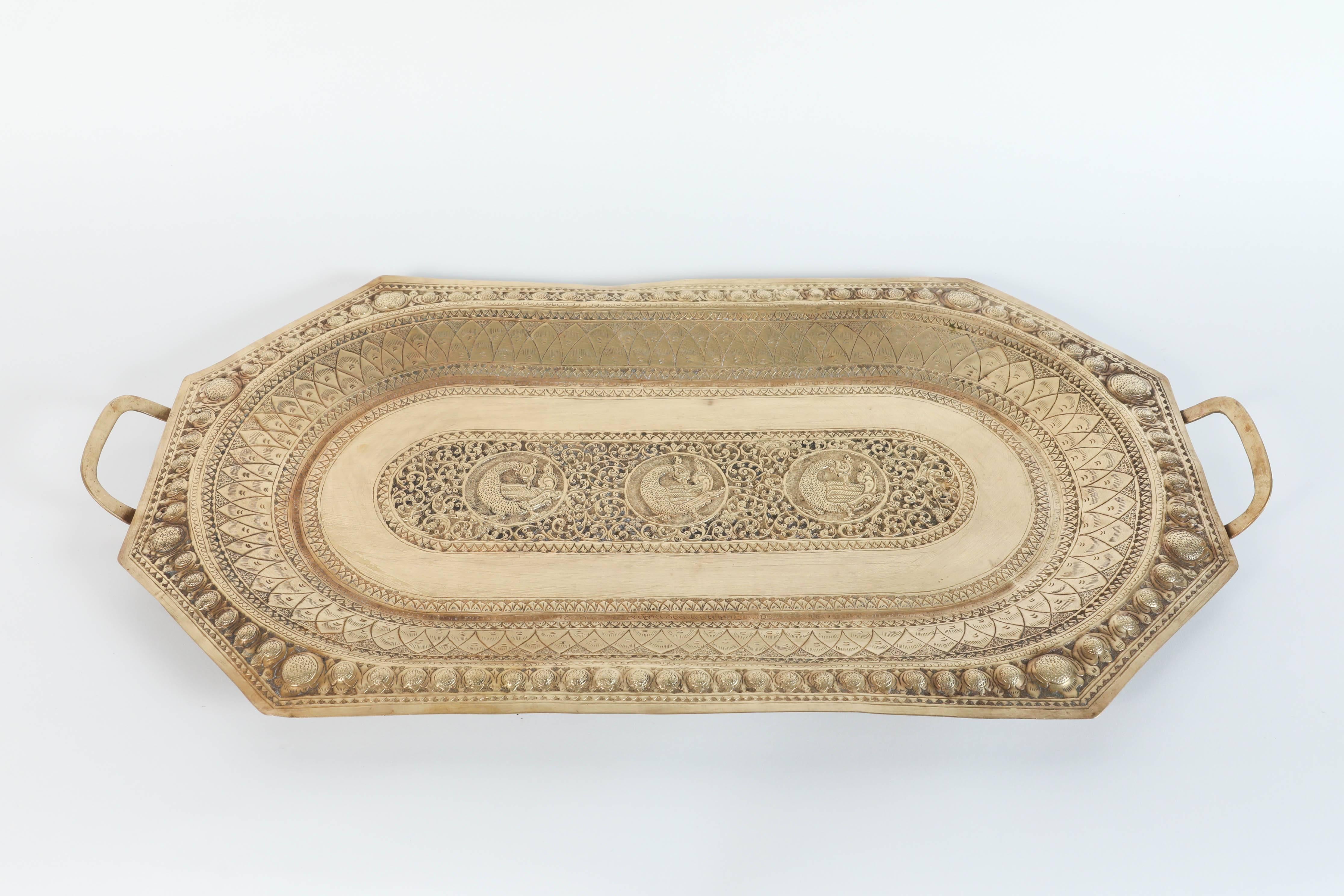 A large Mamluk revival Indo Persian brass charger serving tray with handles.
Large octagonal serving tray platter engraved and finely decorated with peacocks and Moorish geometric designs.
Repoussé floral and foliate motif to the oval center tray