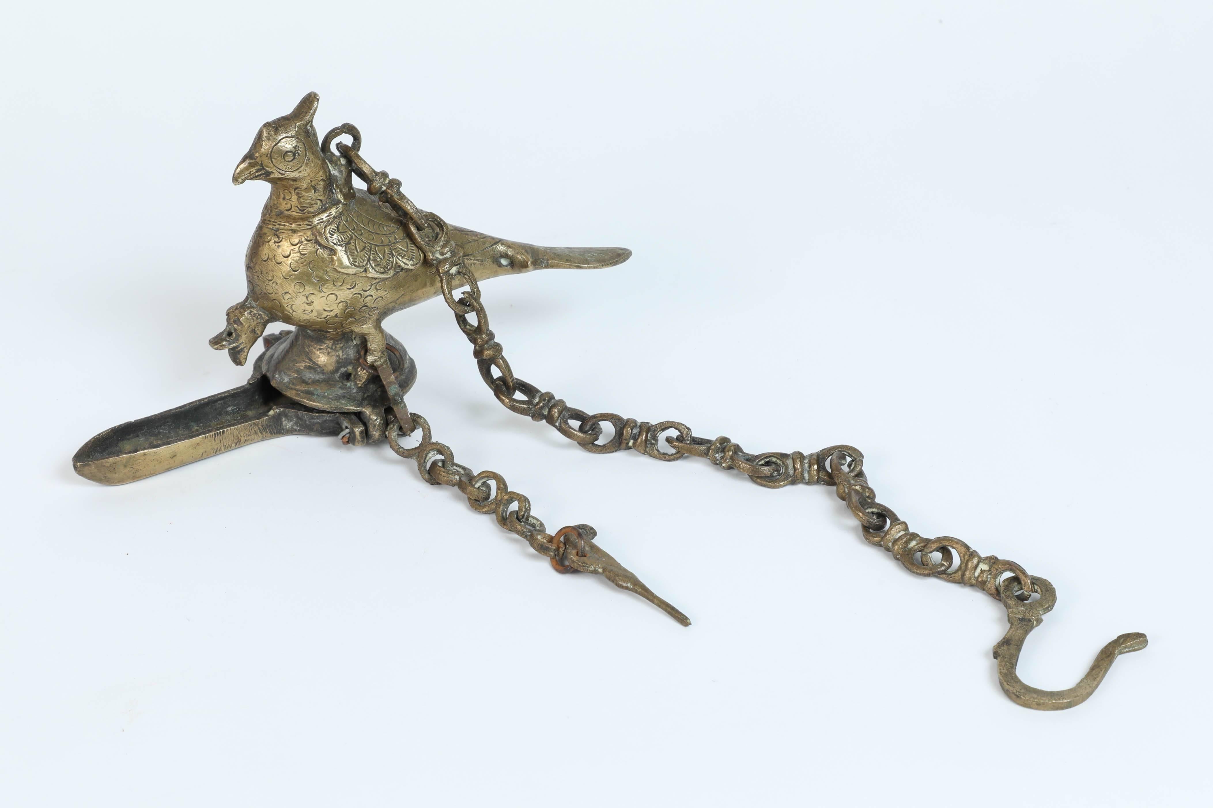 Ancienne lampe à huile suspendue en bronze coulé en forme de paon, un bel oiseau mythique, avec une chaîne de suspension.
Le corps de l'oiseau sert de réservoir pour l'huile tandis que le bec verseur situé en bas est l'emplacement de la mèche de la