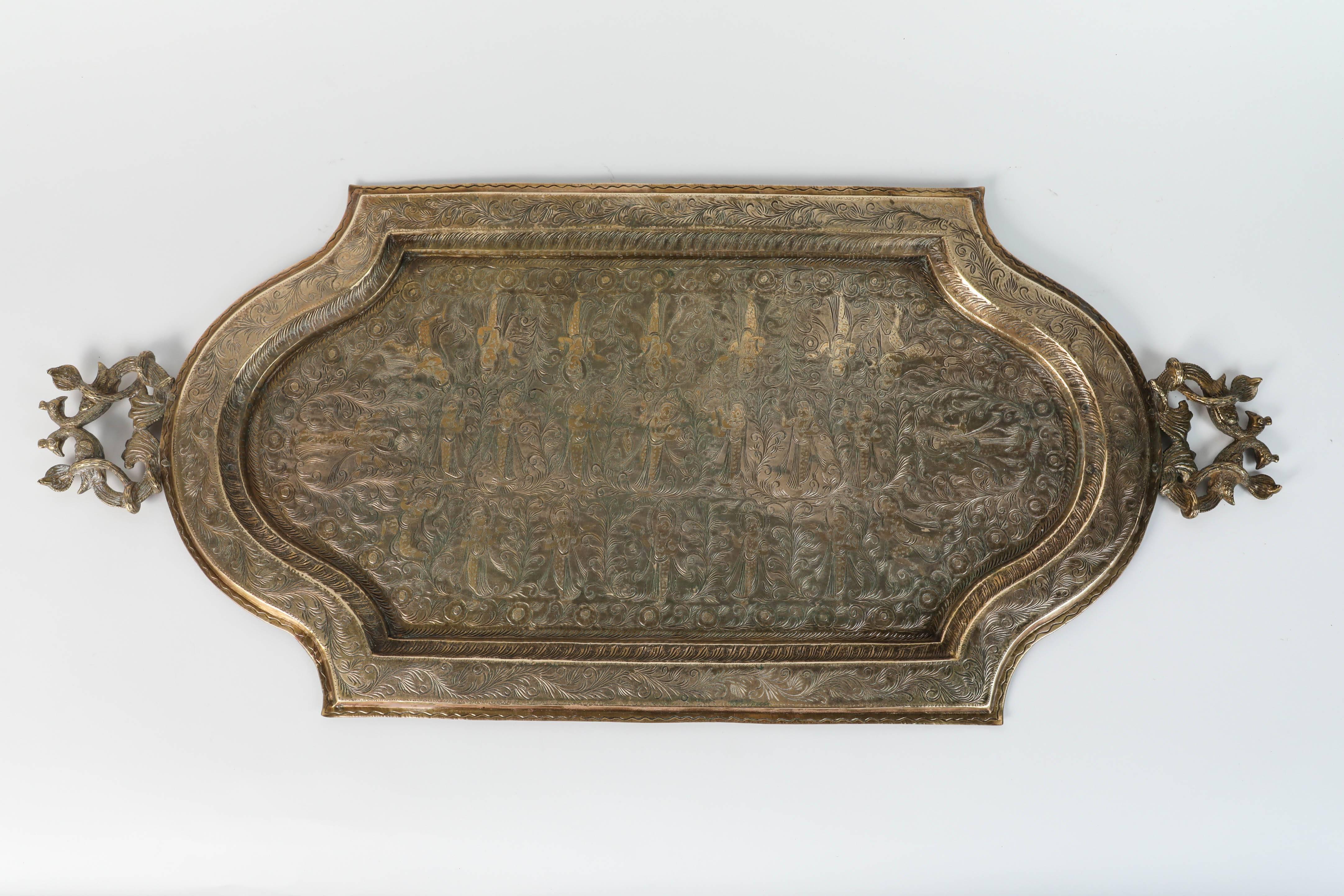 A large antique Mughal Mamluk revival Indo Persian brass charger serving tray.
Engraved and finely decorated with Buddhist Goddess figures and Moorish geometric designs.
Brass repoussé floral and foliate motif to the tray with peacock as well as