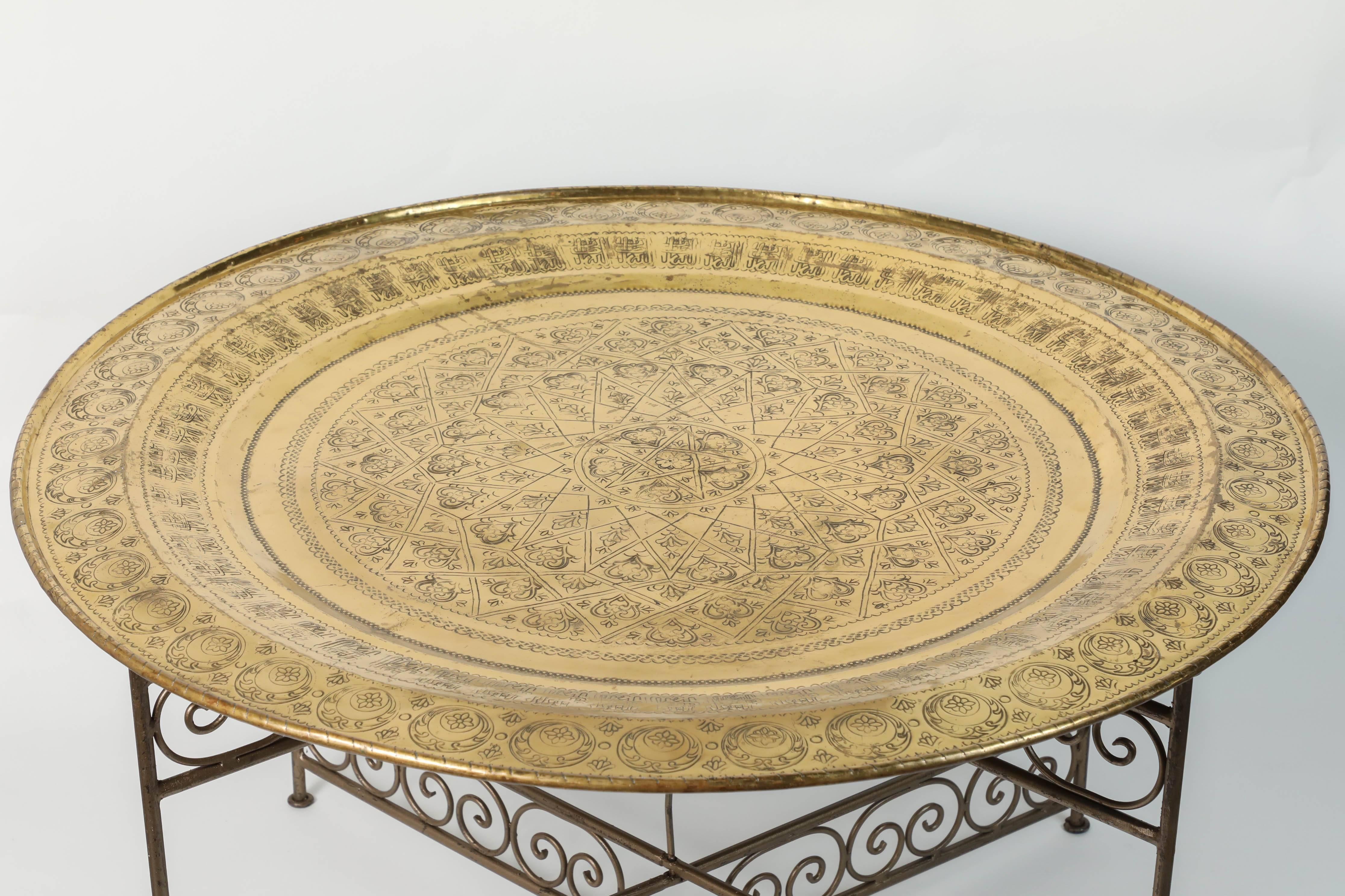 Handcrafted Moroccan round brass tray table on iron base.
Moroccan round brass tray table on iron folding base.
Nice handcrafted polished brass tray, hand-hammered with Moroccan traditional designs. 
Handmade in Fez by Master artisans. 
Great to
