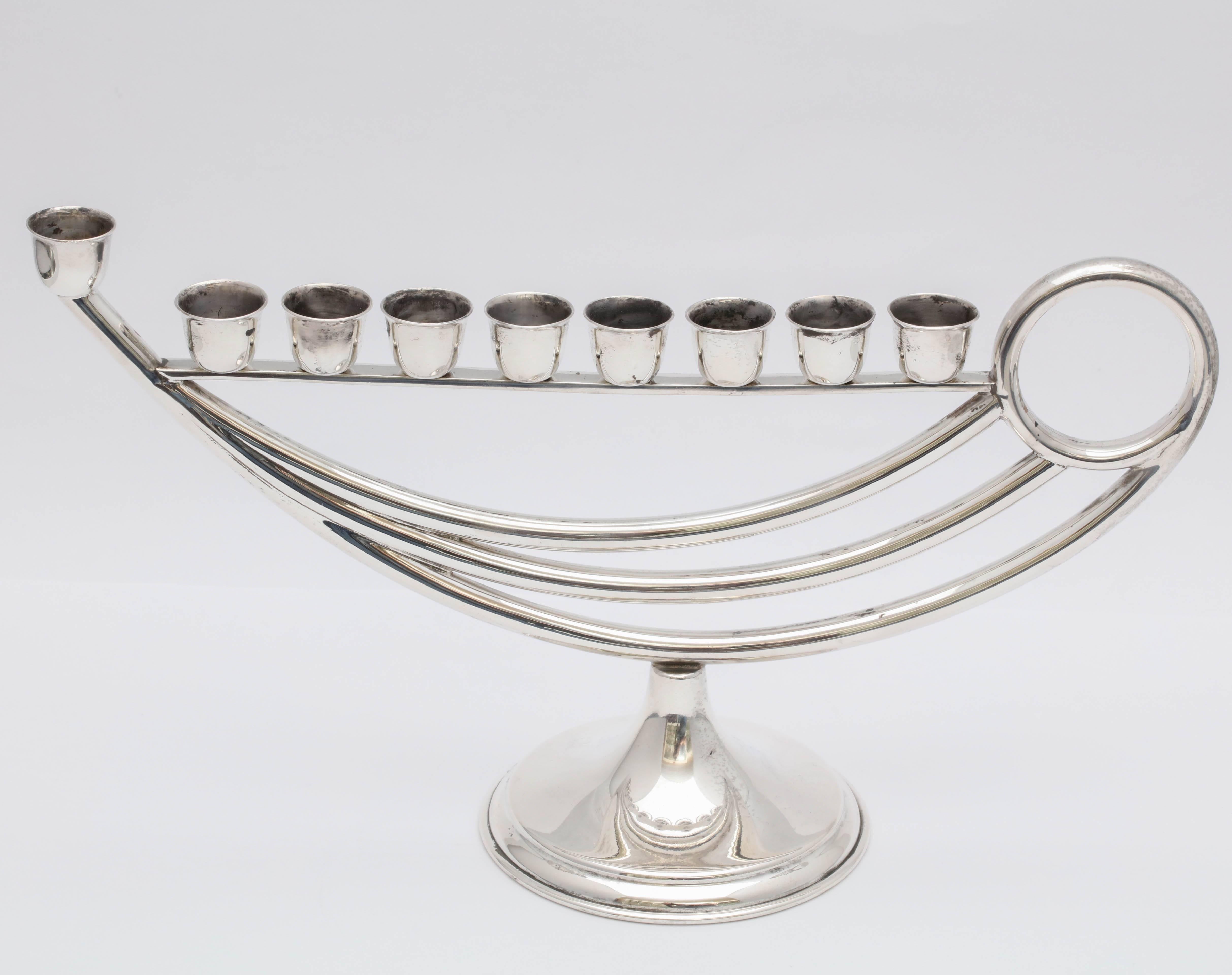 Unusual, sterling silver, midcentury, oil lamp - shaped menorah, Mexico, circa 1950s-1960s. Graceful design. Each candle cup is separately screwed into the menorah. Measures: 10 inches long x 5 3/4 inches high (at highest point) x 3 1/2 inches