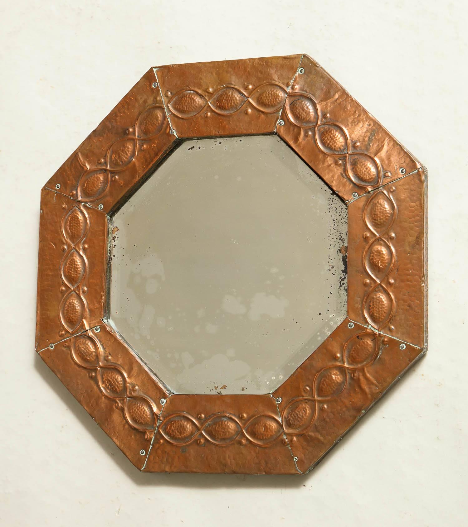 Fine English Arts & Crafts period hammered copper octagonal mirror, the eight panels with Celtic chain decoration and retaining original bevelled glass, circa 1890.