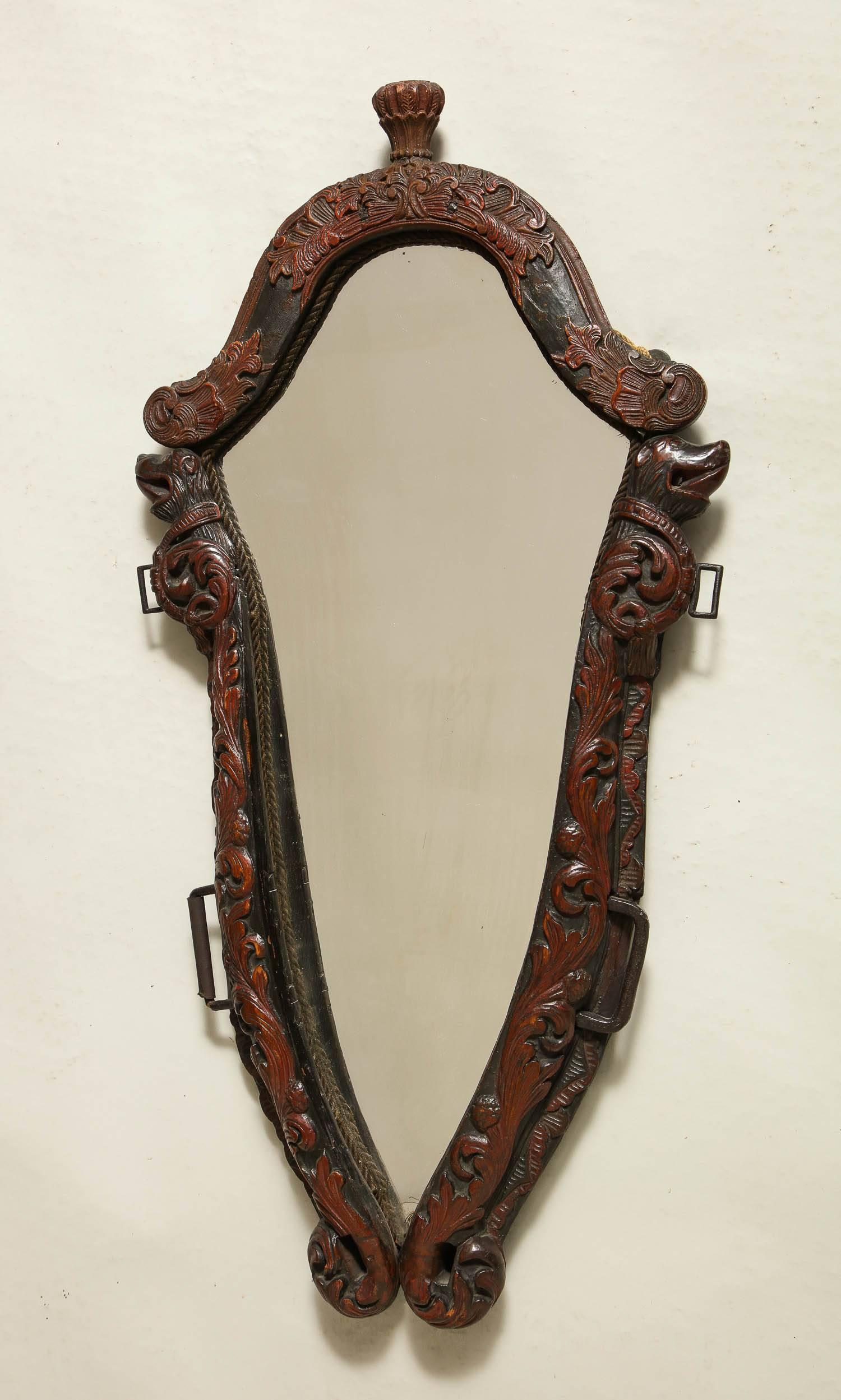 Unusual Norwegian Folk Art mirror constructed from an 18th century horse harness or “haim” having bear or lion faces and foliate carving and original paint. It was made into a mirror, circa 1910.