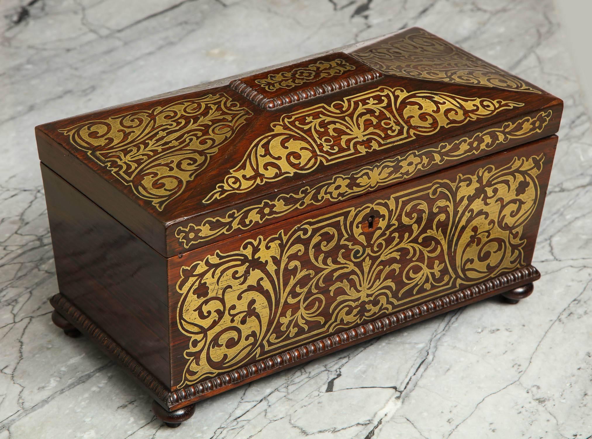 Very fine William IV rosewood tea caddy with brass Boulle inlay, the canted top with bobbin turned molding and four inlaid panels, the front similarly, but more elaborately, decorated, the plain interior with inlaid panel to underside of lid.