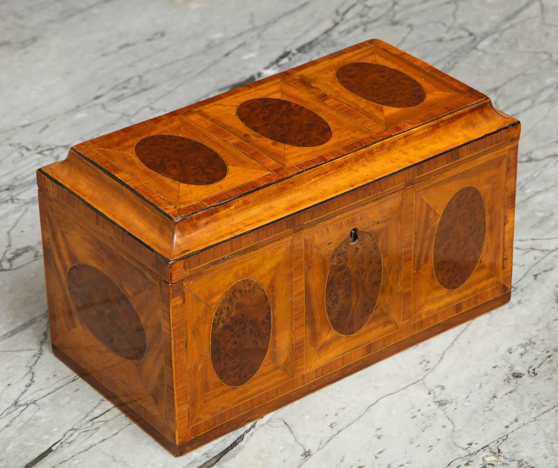 Fine George III inlaid satinwood tea caddy having oval inlays of burl yew wood in a mitered satinwood panel, the top with concave corners, the interior with large satinwood patera on burr yew ground.