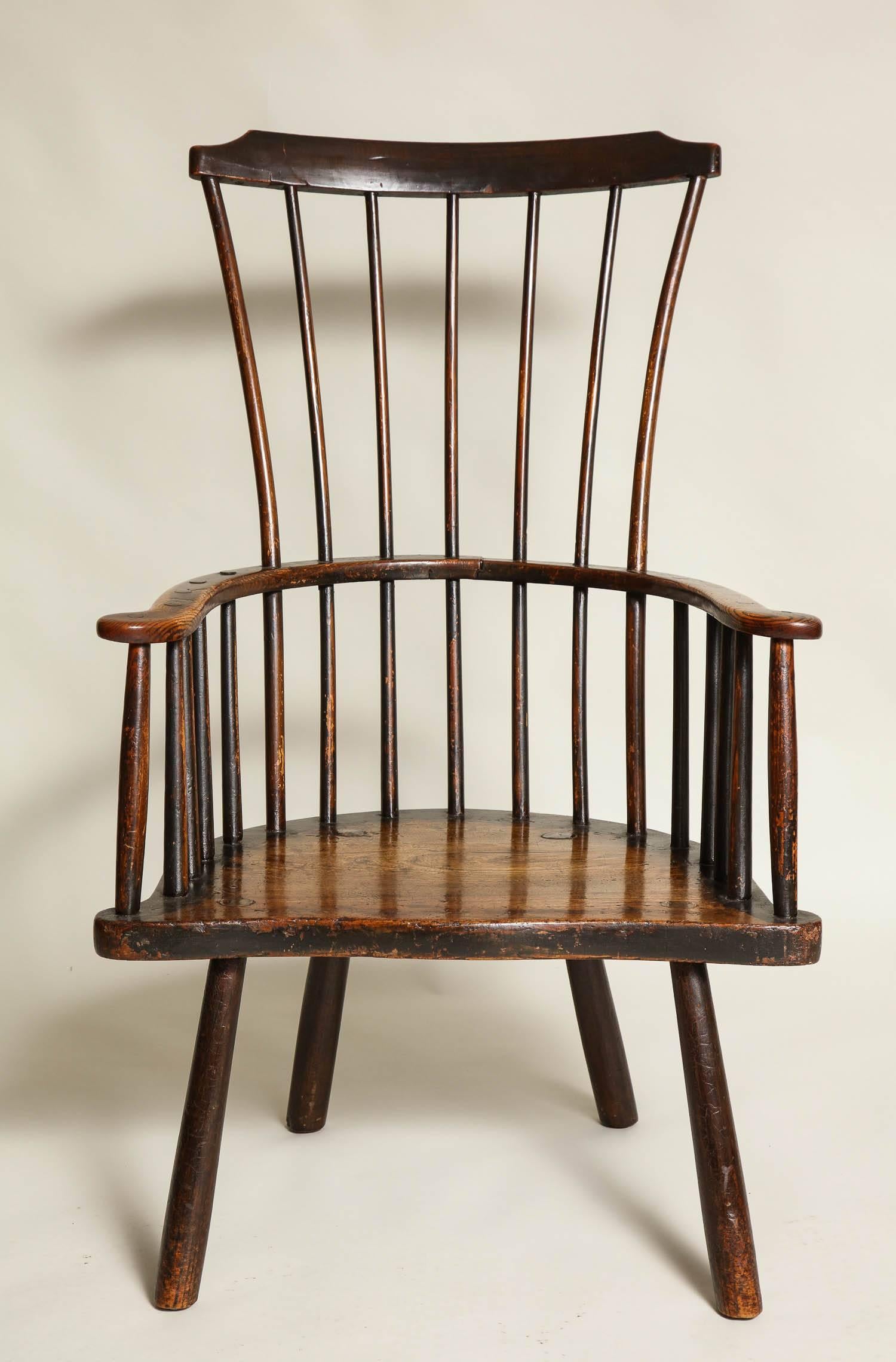 Fine 18th century English comb back windsor armchair, probably West Country, the shaped crest supported by spoke-shaved spindles, the continuous arm and shallow seat with same profile, standing on four spoke shaved pole legs, the whole possessing a