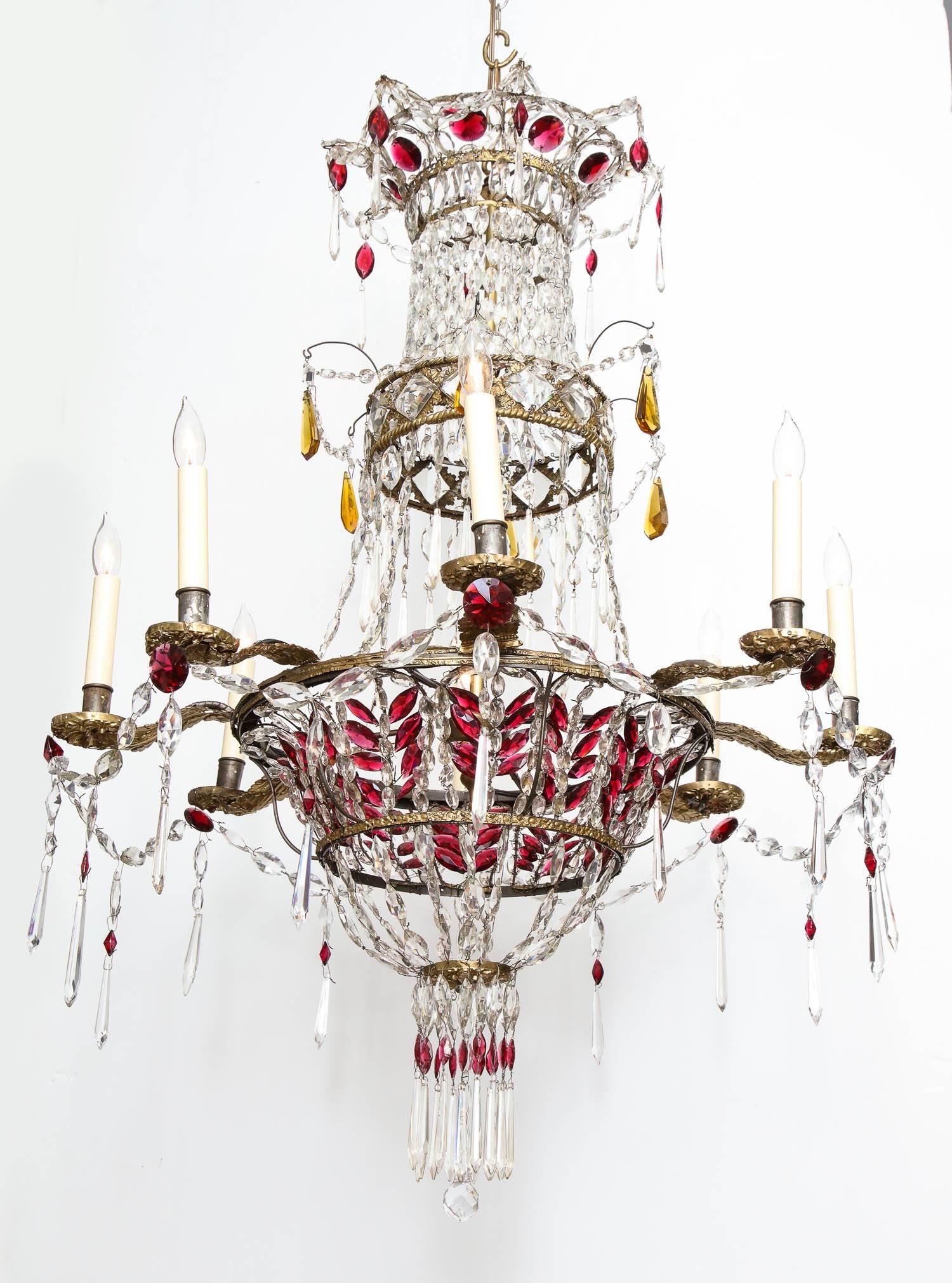 Elegant and decorative early 19th century Gustavian neoclassical eight-light chandelier, having cranberry, amber and clear crystal drops, the frame and arms decorated with repousse lacquered gilt brass mounts on an iron and wirework frame, now wired