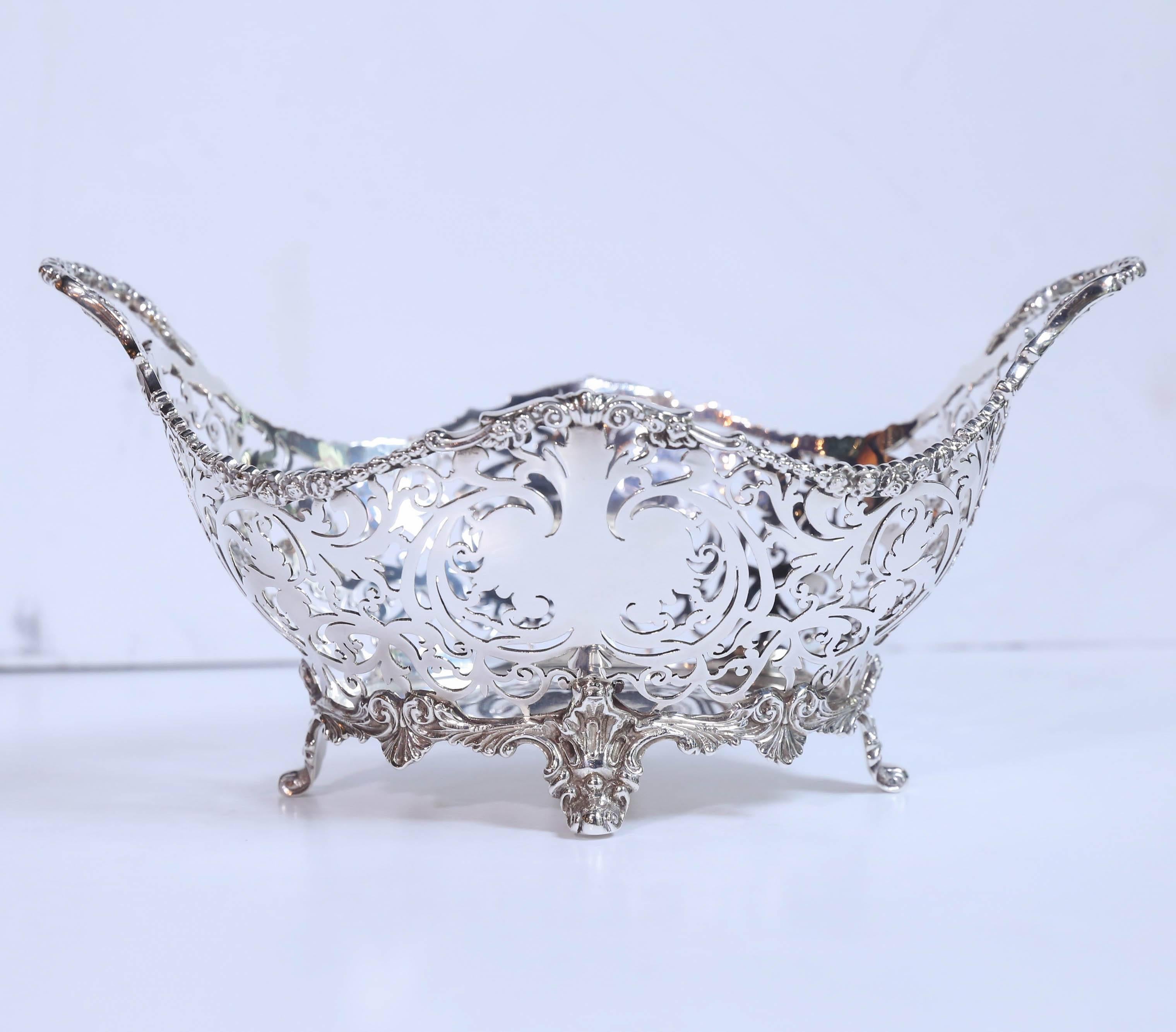 Very fine antique English sterling silver oval shaped basket with all
Over reticulated pattern that is in a scrolling pattern. It is raised on
fine splayed and curled pattern feet.