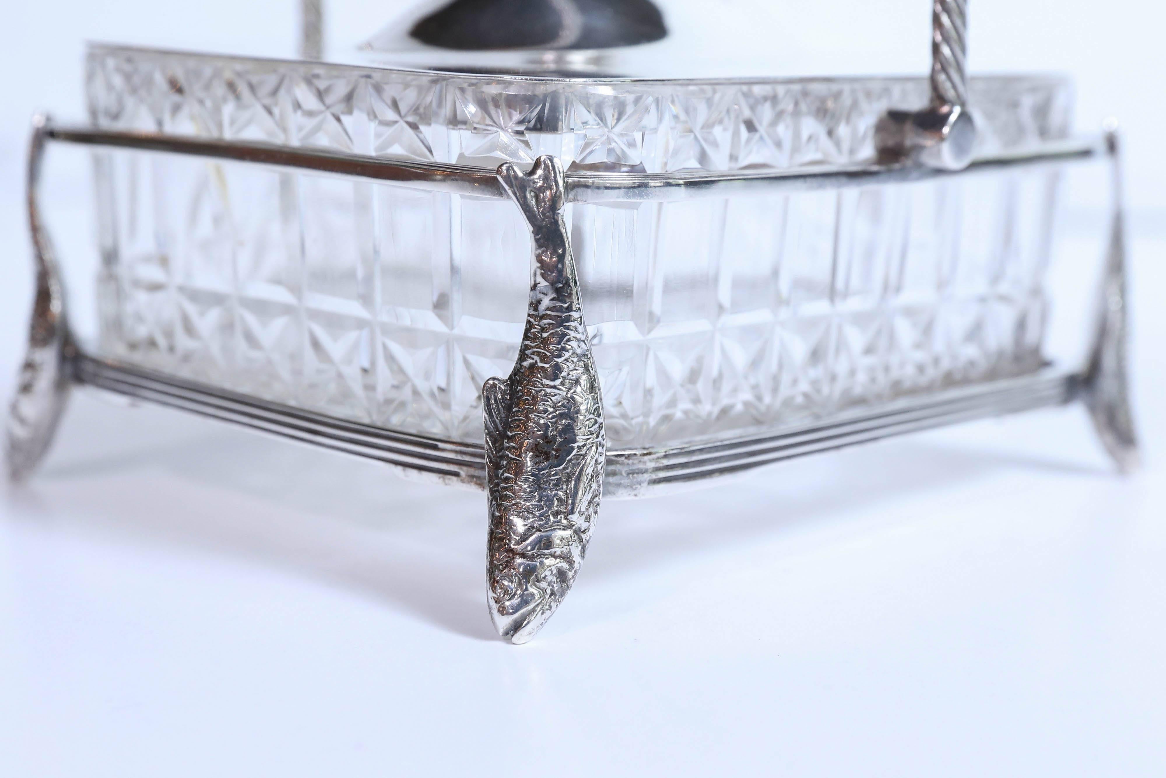 Lovely epns silver plated basket holding a crystal dish
Designed for serving sardines. A roped handle to move
The sever enhances this beautiful dish. Fish designs form the 
Feet on all four corners
The liner is made of crystal. The top is domed