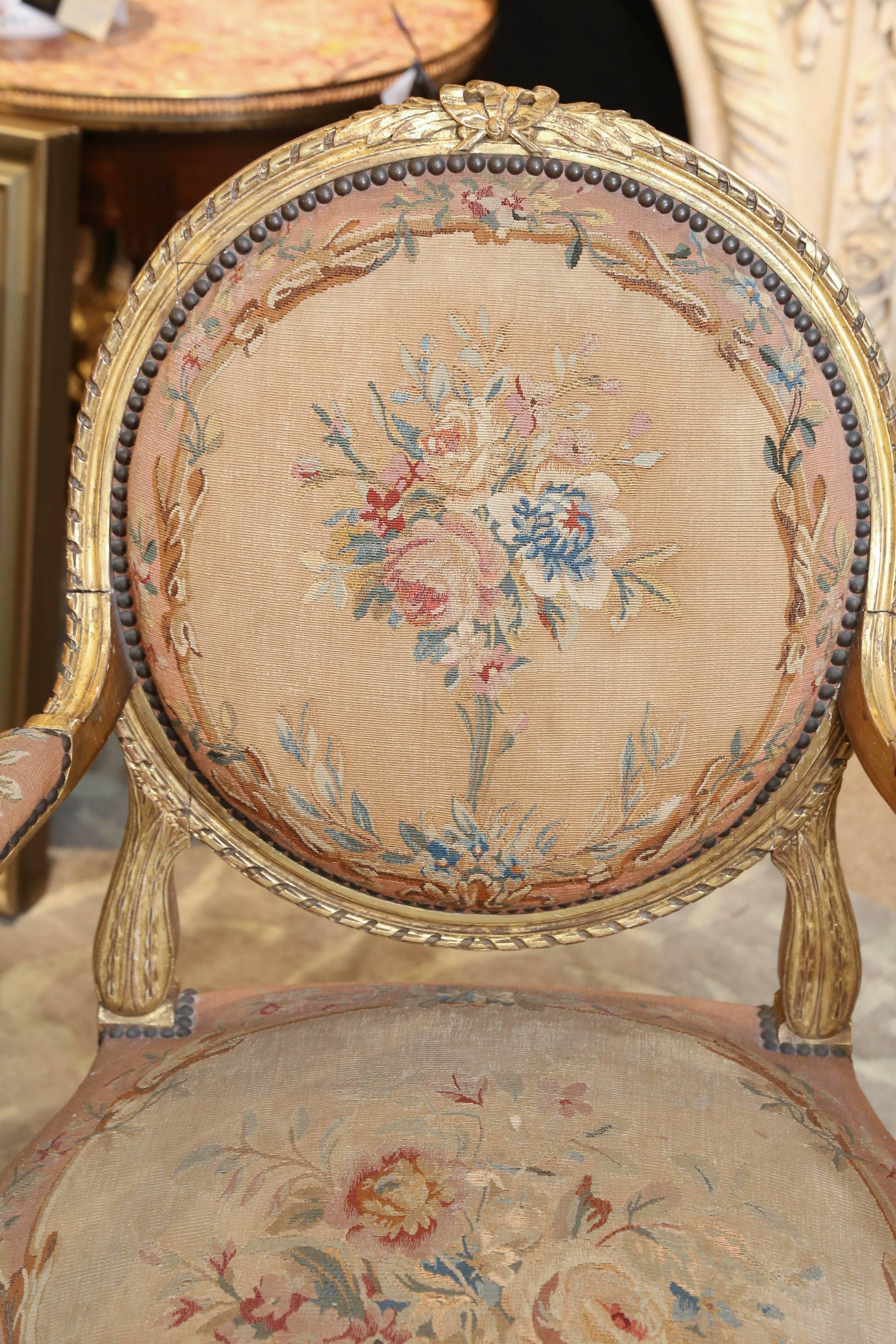 Original Aubusson upholstery and 19th century giltwood fauteuils in very good
condition with very little wear. Floral design in rose, teal and pale green
colors. A bow design at the crest of the chairs embellishes the overall.
Reeded legs and