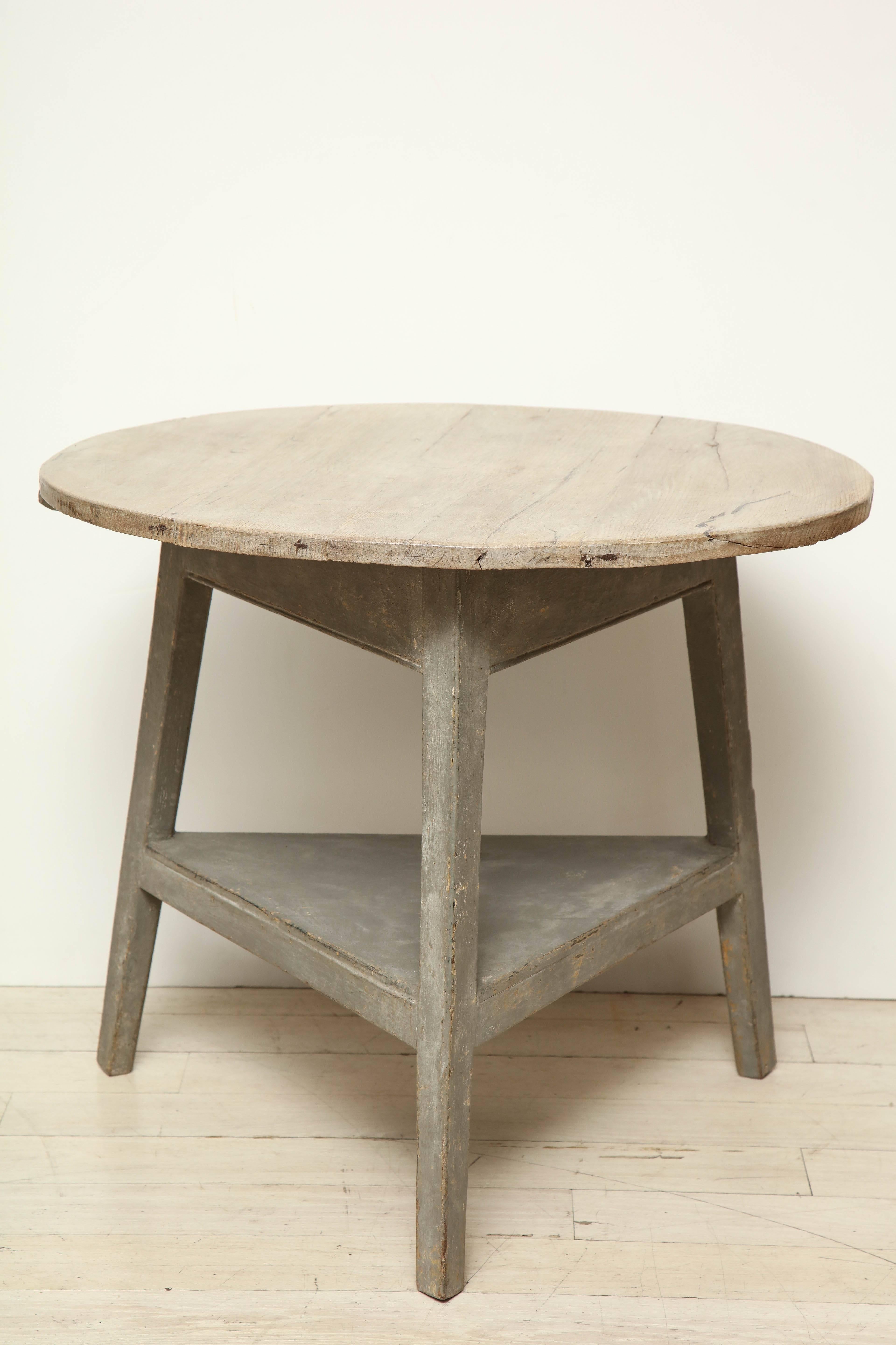 A 19th century French wood cricket table with bleached oak top, painted gray base and bottom shelf, France, circa 1850.