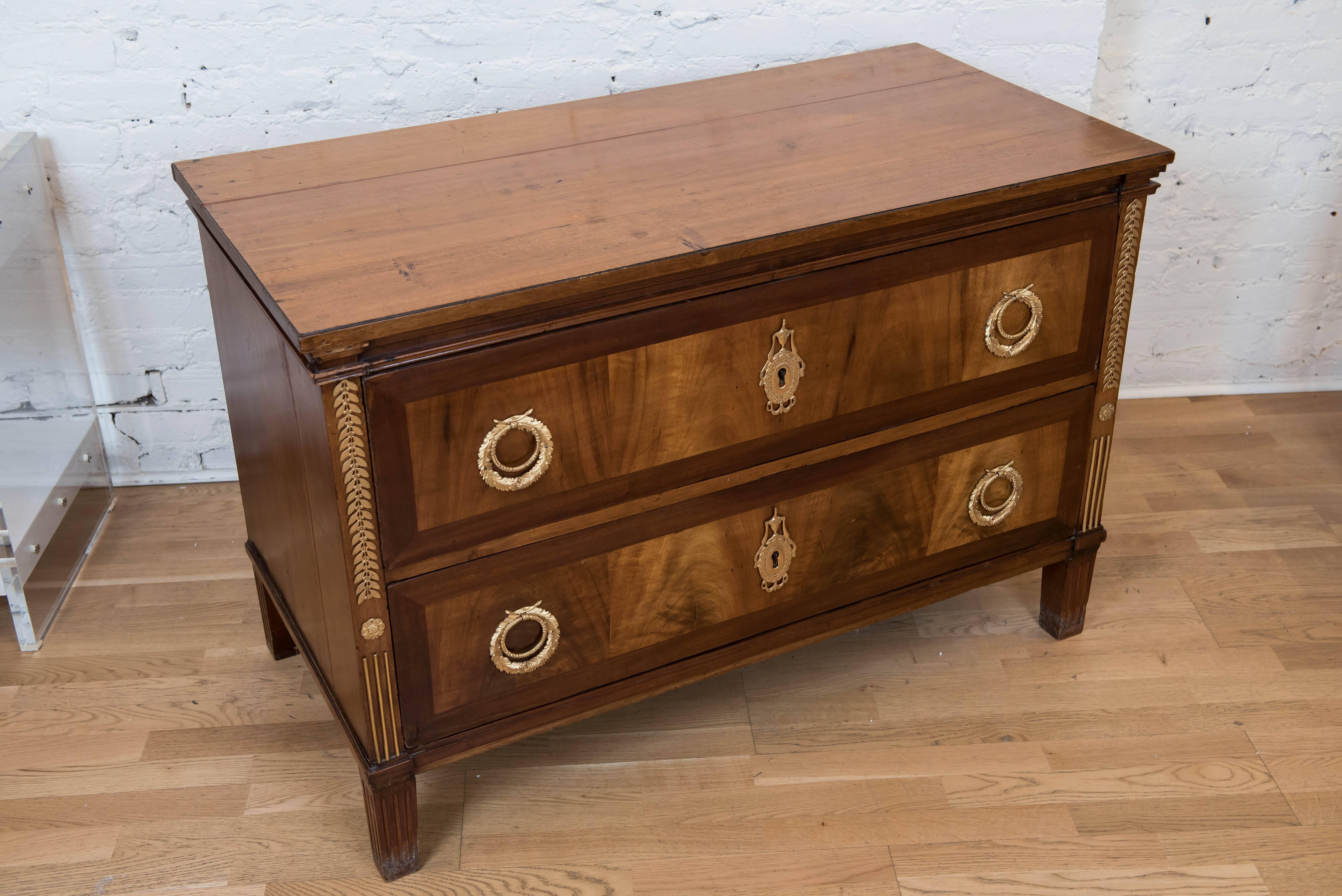 This sumptuous and nicely designed two-drawer commode with light walnut wood top with
bookmatched veneer fronts over a pine structure is adorned with decorative gilt bronze
handles, key holes and decorations. Great piece, good lines, interesting