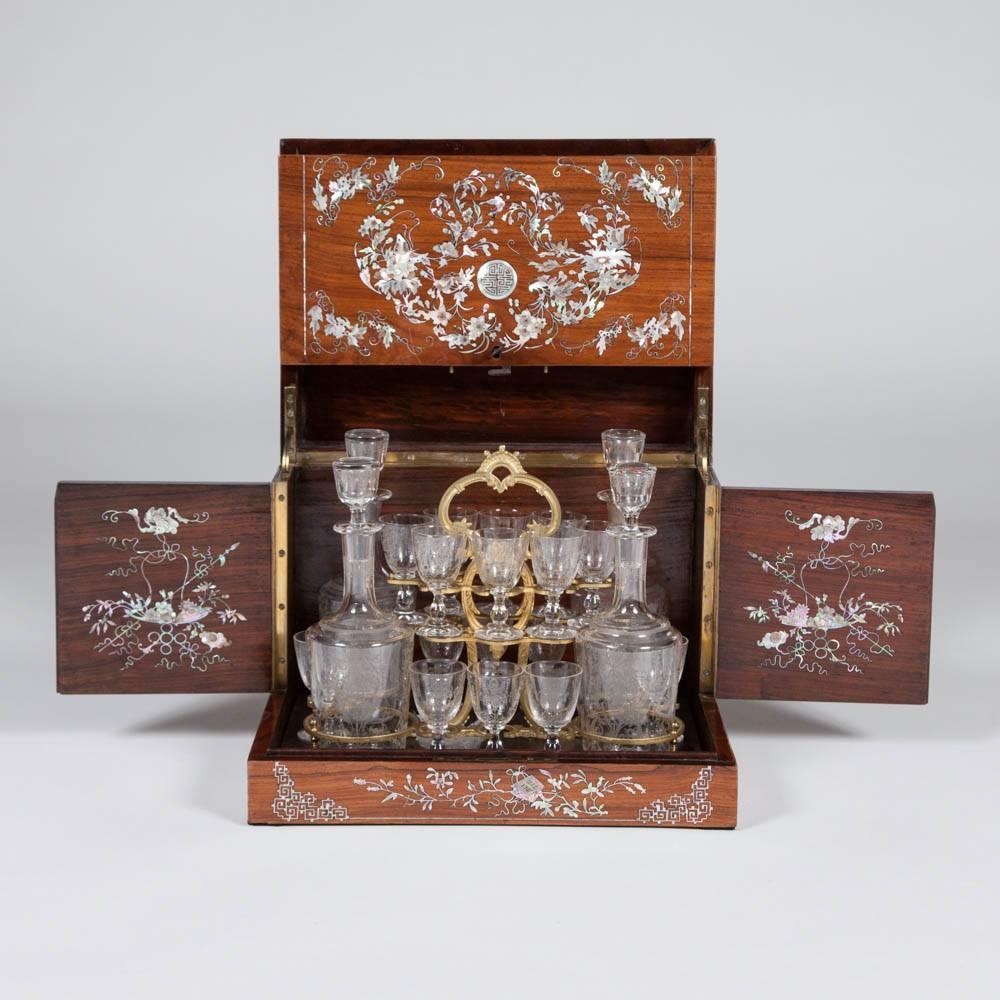 A late 19th century mother-of-pearl inlaid hardwood Chinese export drinks case enclosing a gilt frame tray with French etched glassware. 

The glassware comprises of four decanters and 16 liqueur glasses.