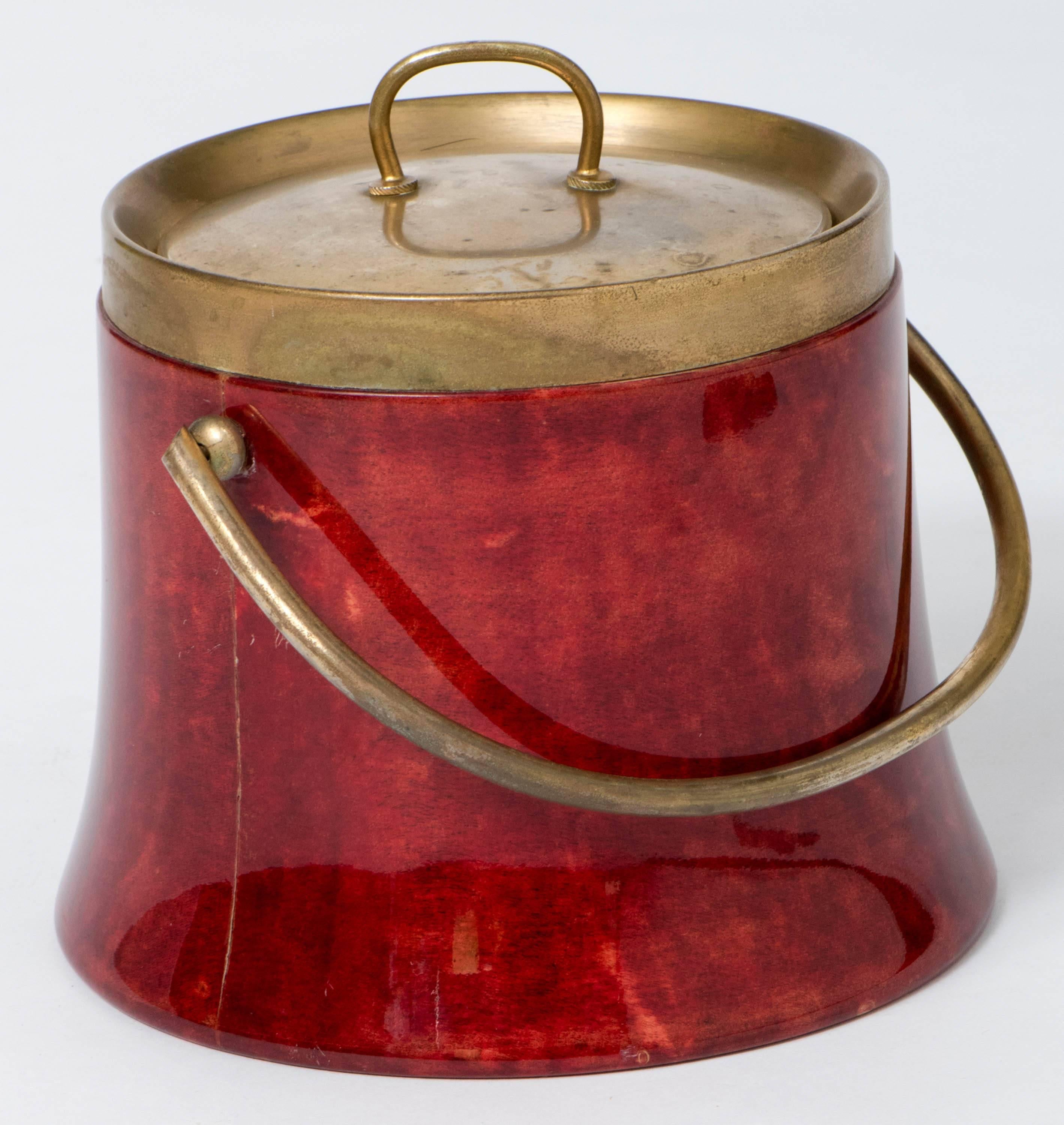 An Aldo Tura ice bucket
Reddish lacquered bucket.
Brass handle, mounts and lid,
Italy,
circa 1950
Measures: 21 cm high x 19 cm diameter.
 