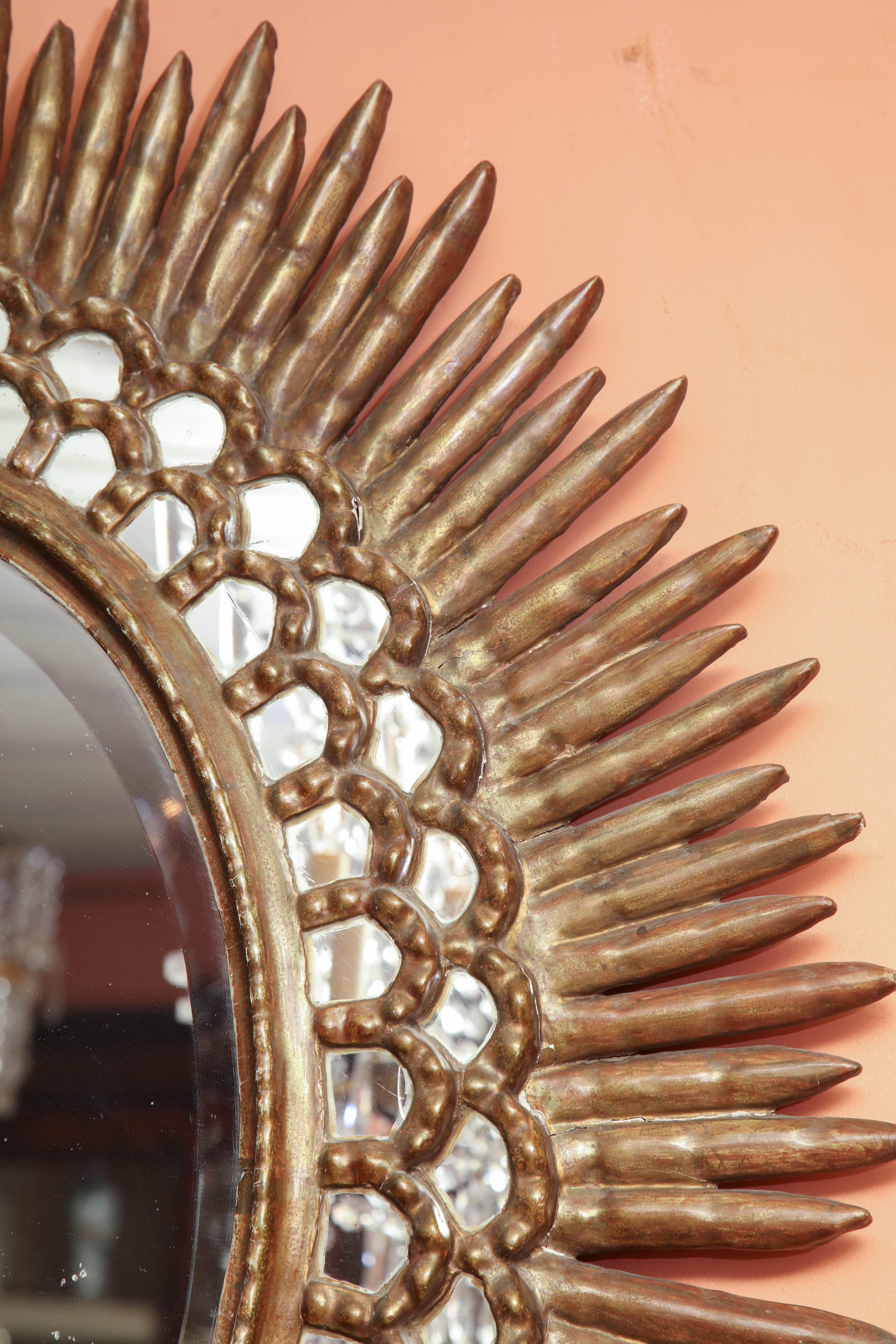 Oval carved, faceted and rayed sunburst mirror.