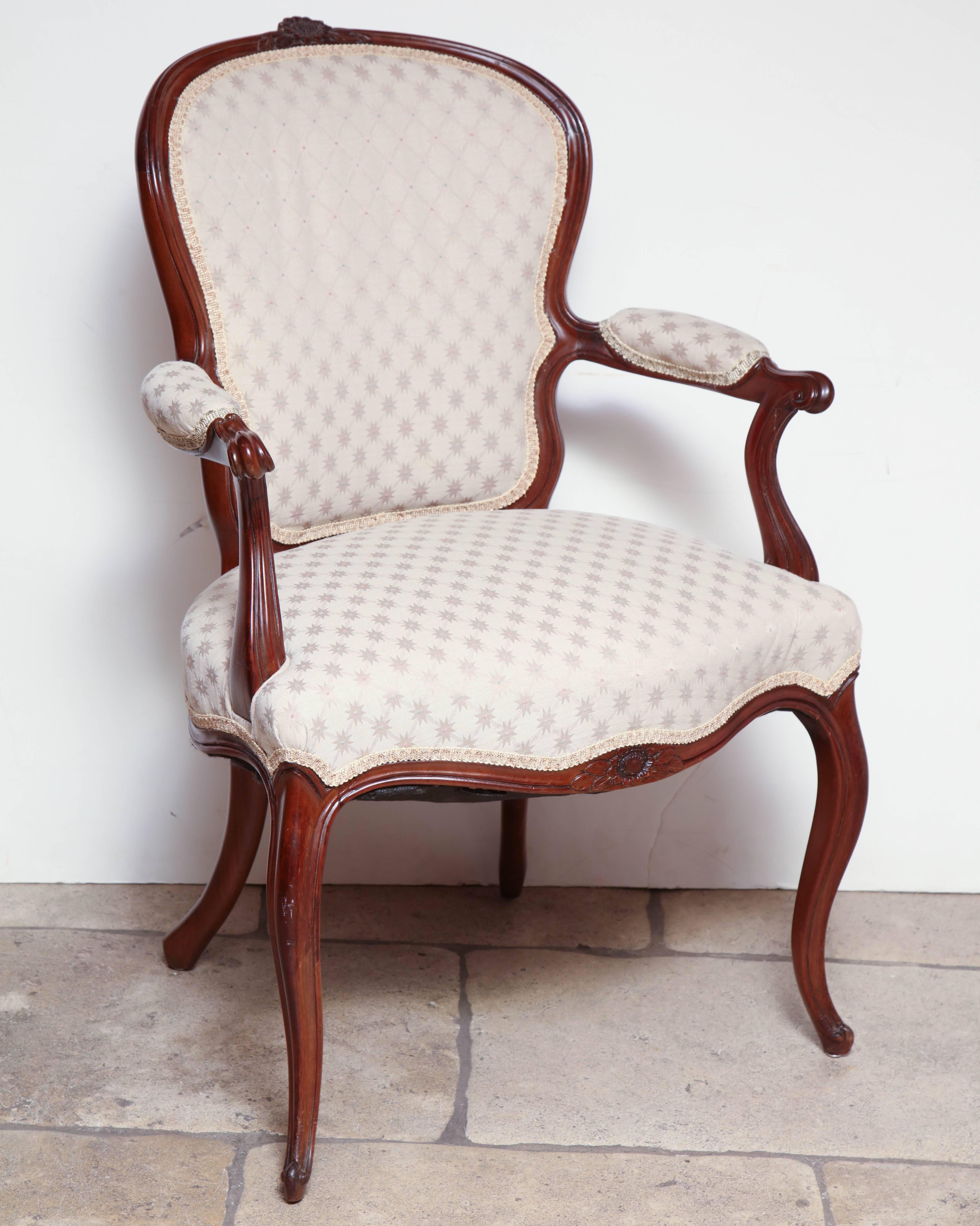 A pair of George III (Hepplewhite) carved open armchairs with upholstered back, arms and cushions with a serpentine carve rail and cabriole legs.