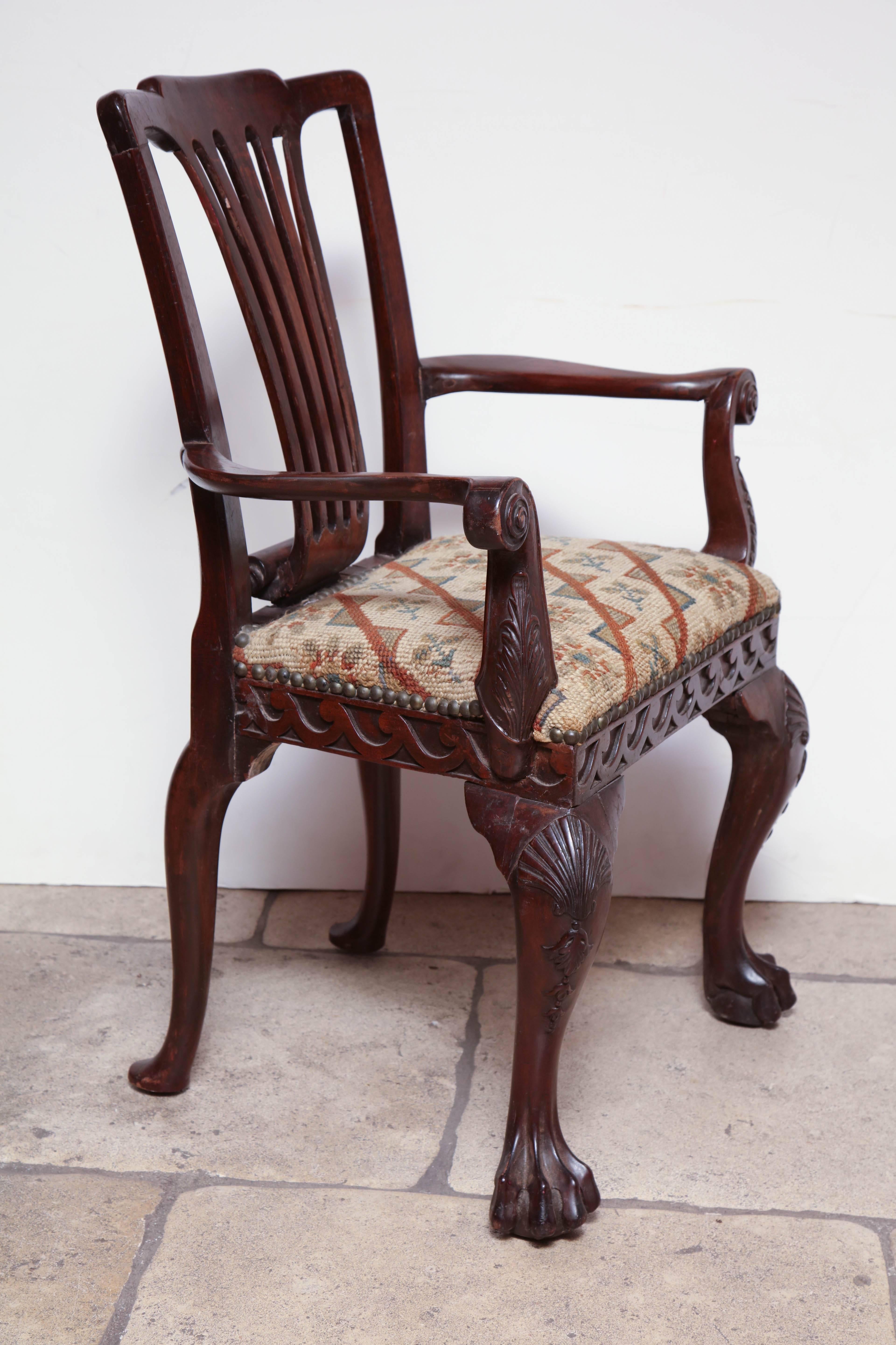 Irish George II carved mahogany Child's armchair with Vitruvian scroll rails, shell carved knees and carved Paw Feet.