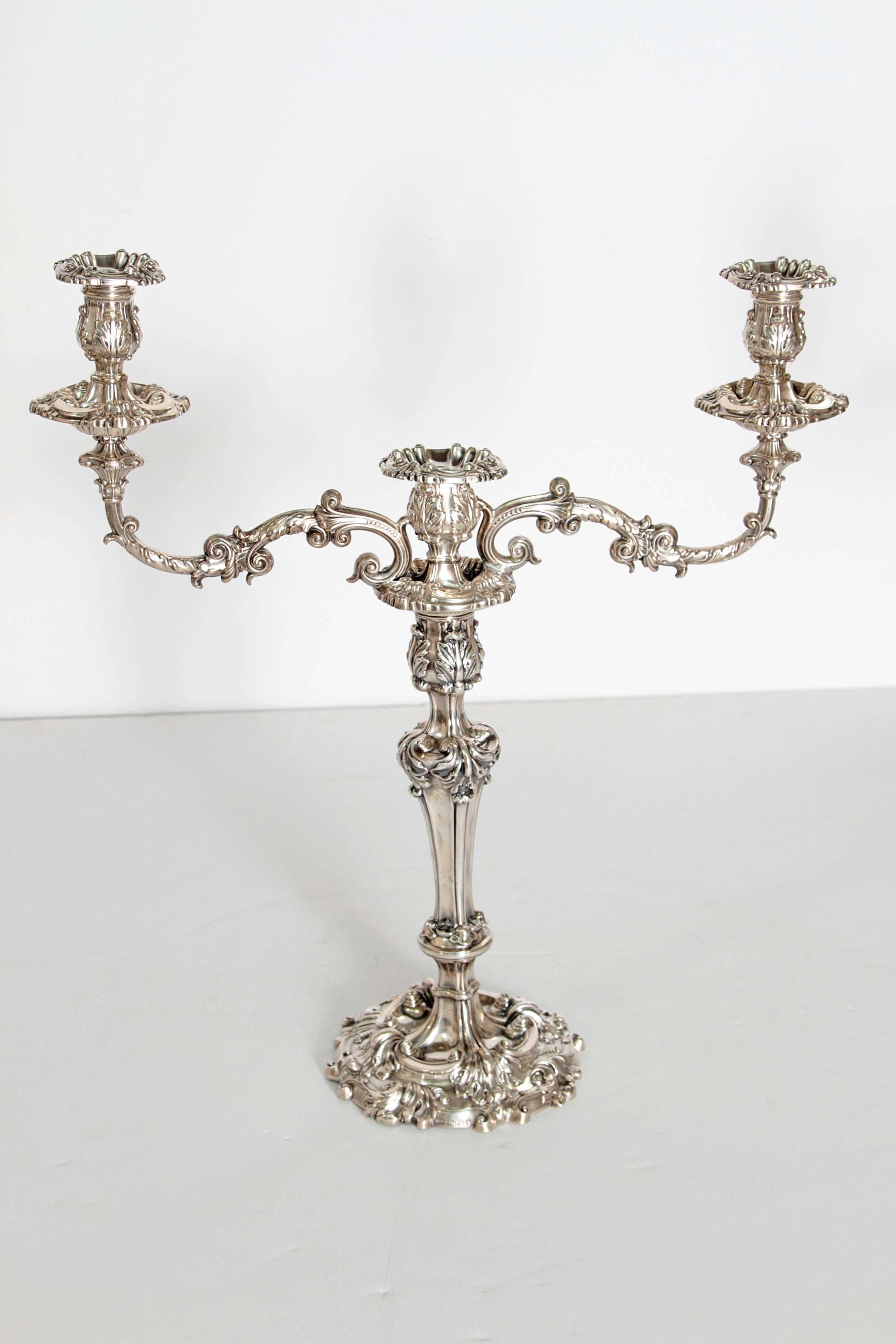 A pair of English Sheffield sterling silver candelabra with very elaborate detail. These early candlesticks convert to a three light candelabra with later additions. Base circa 1816 by John Watson & Son, top circa 1837 by Henry Wilkinson & Co.