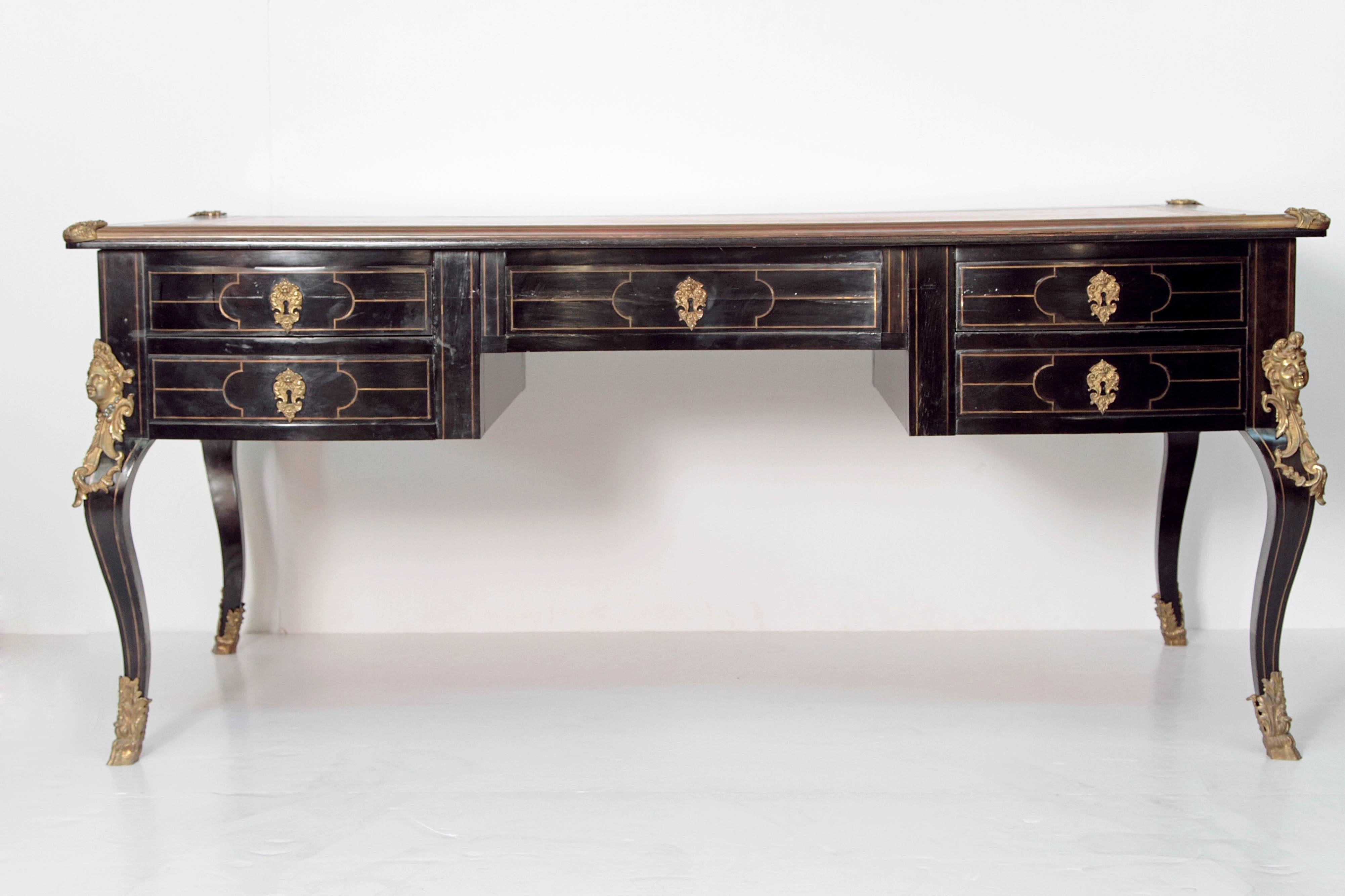 A sturdy and substantial 19th century French bureau plat, Louis XV style, black lacquer with gilt bronze mounts, keyhole eschuchions, and gilt decoration / detail, tan leather writing surface with embossed and gilded border, two drawers on either