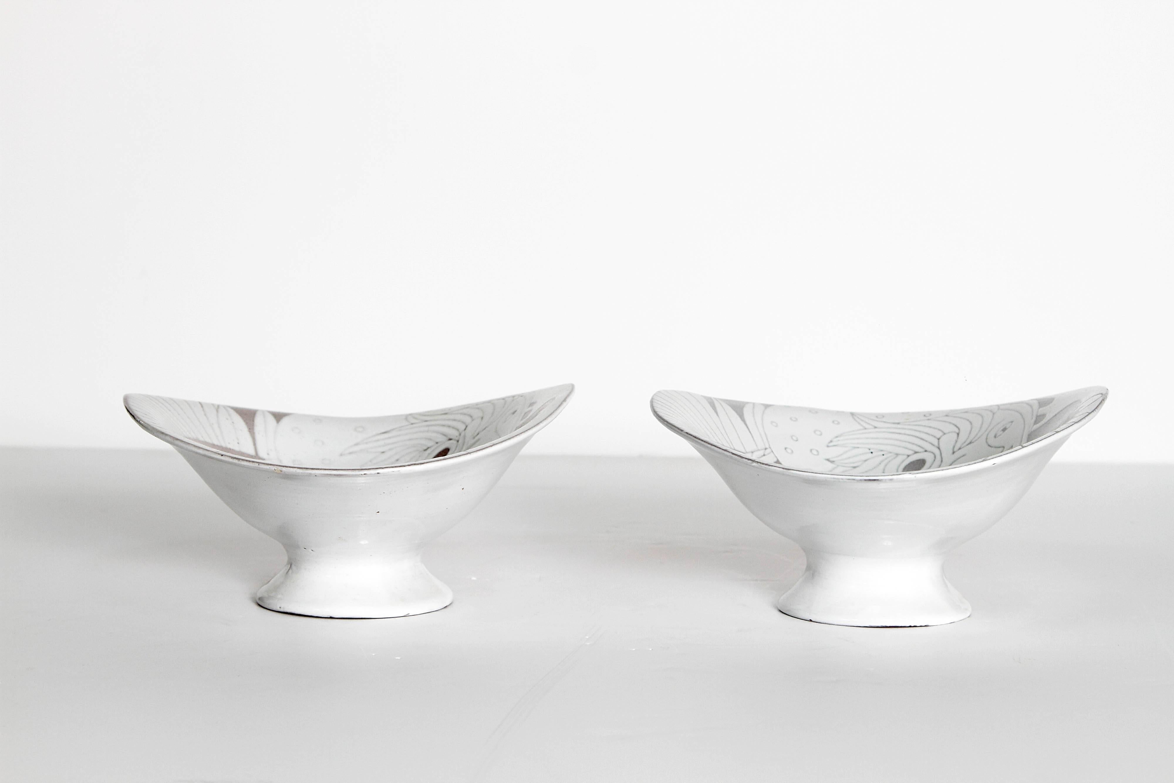 Mid-century curved bowl on pedestal with white and grey glaze. Incised two face woman with streaming hair and a fish. Makers stamp on base.
