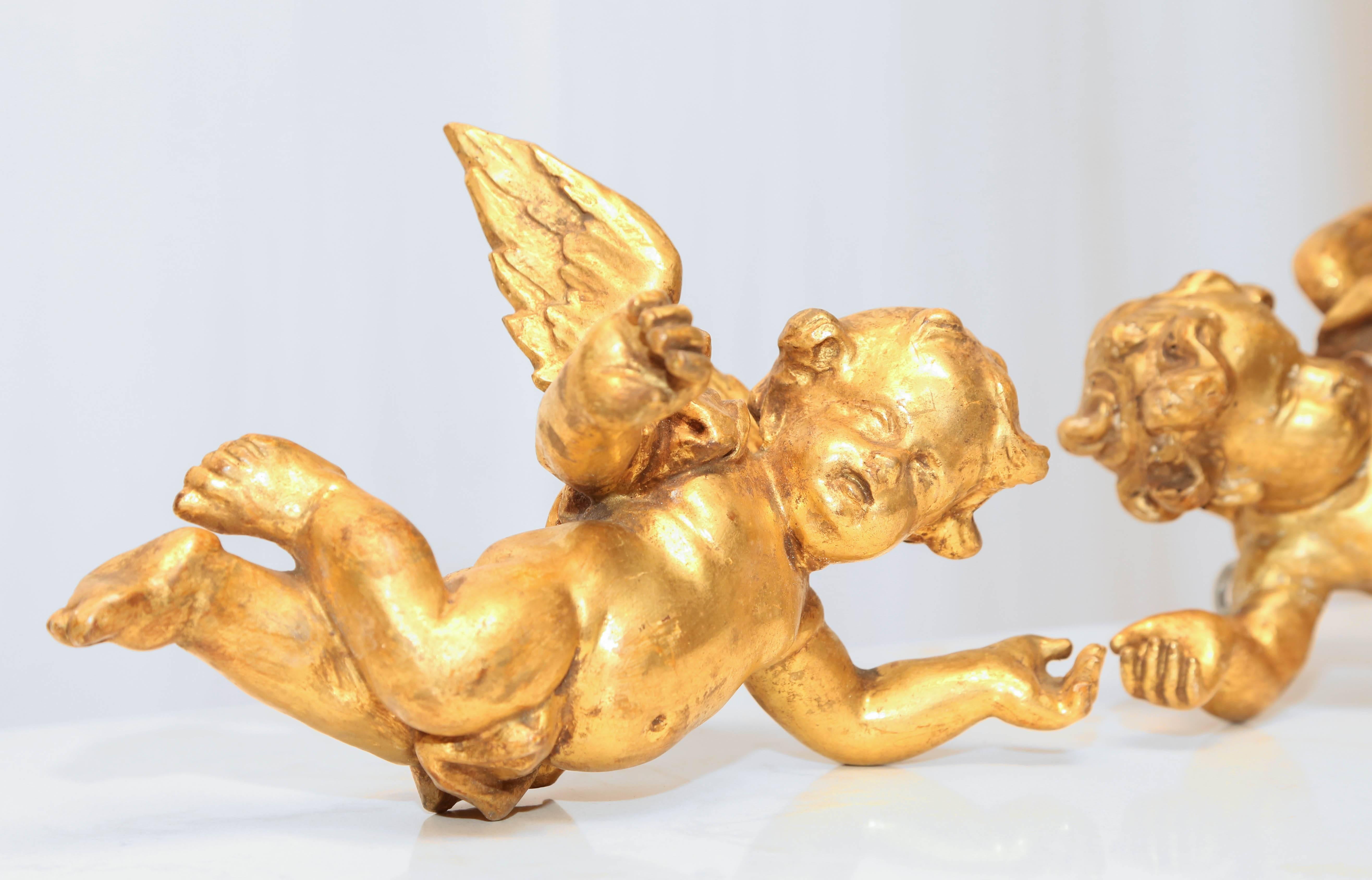 Pair of late 18th century or early 19th century carved Italian Putti. Original gold gilt showing appropriate wear for their age. The size of the putti are 10