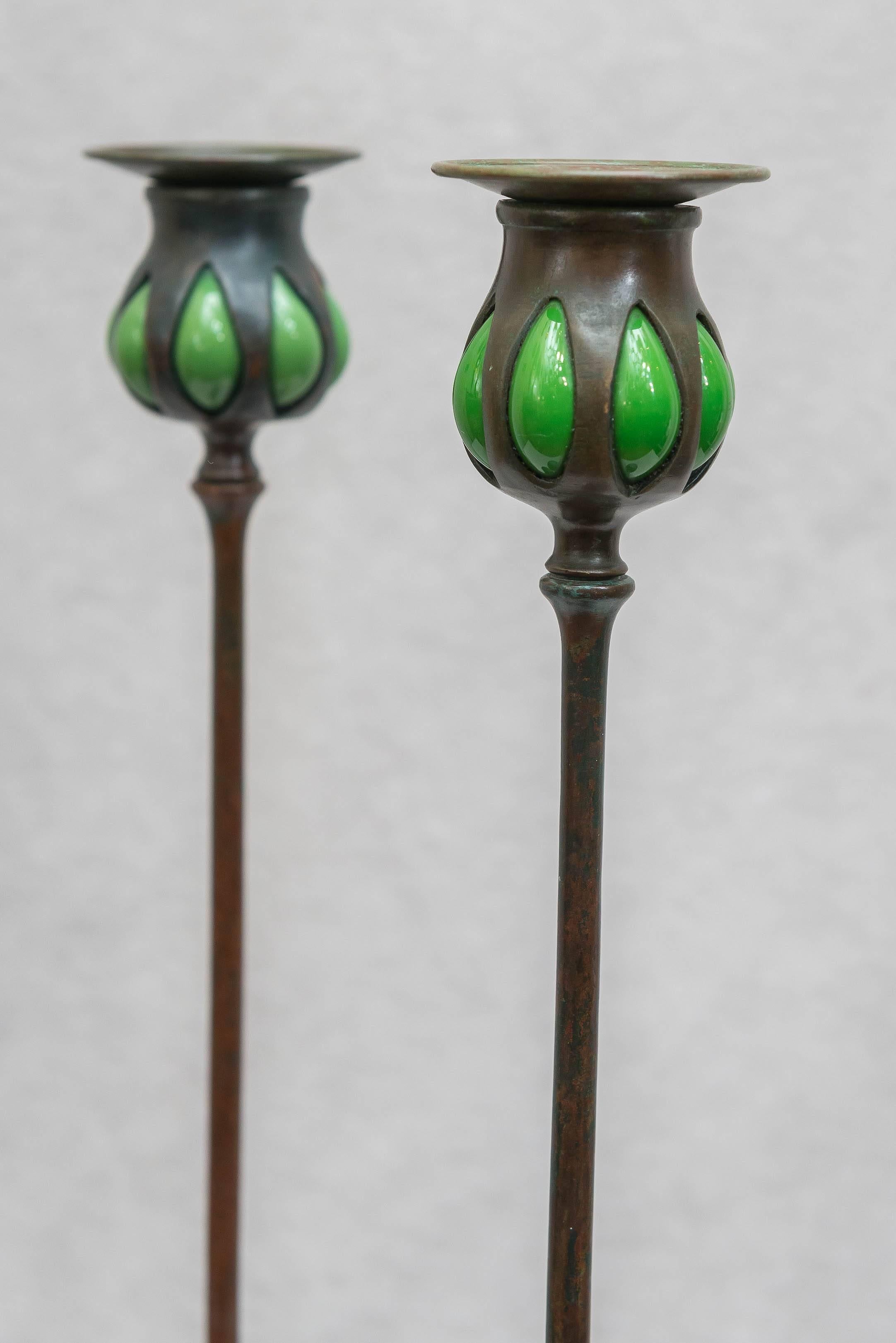 I am sure do not have to tell you much about Tiffany Studios. Their name suggests the best you can buy. Here are a handsome and graceful pair of properly signed Tiffany candlesticks. The added bonus here is the glass that adorns these candlesticks.