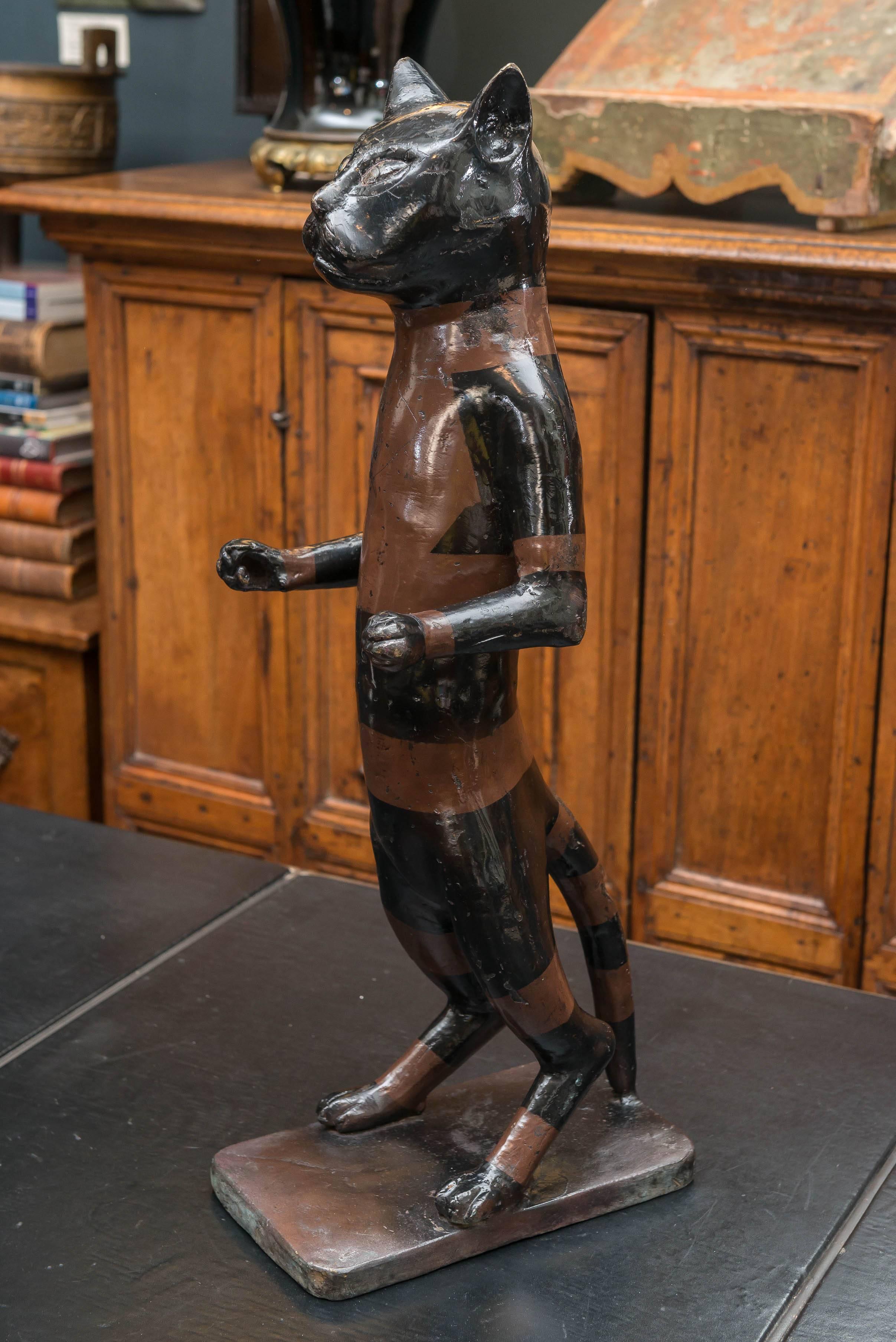 Early 20th Century Cast Brass Standing Cat with old paint decoration. Curious pugnacious pose standing with arms stretched out leaning back on it's tail. Once presumed to have been holding something in the outstretched arms. Prolific lacerations,