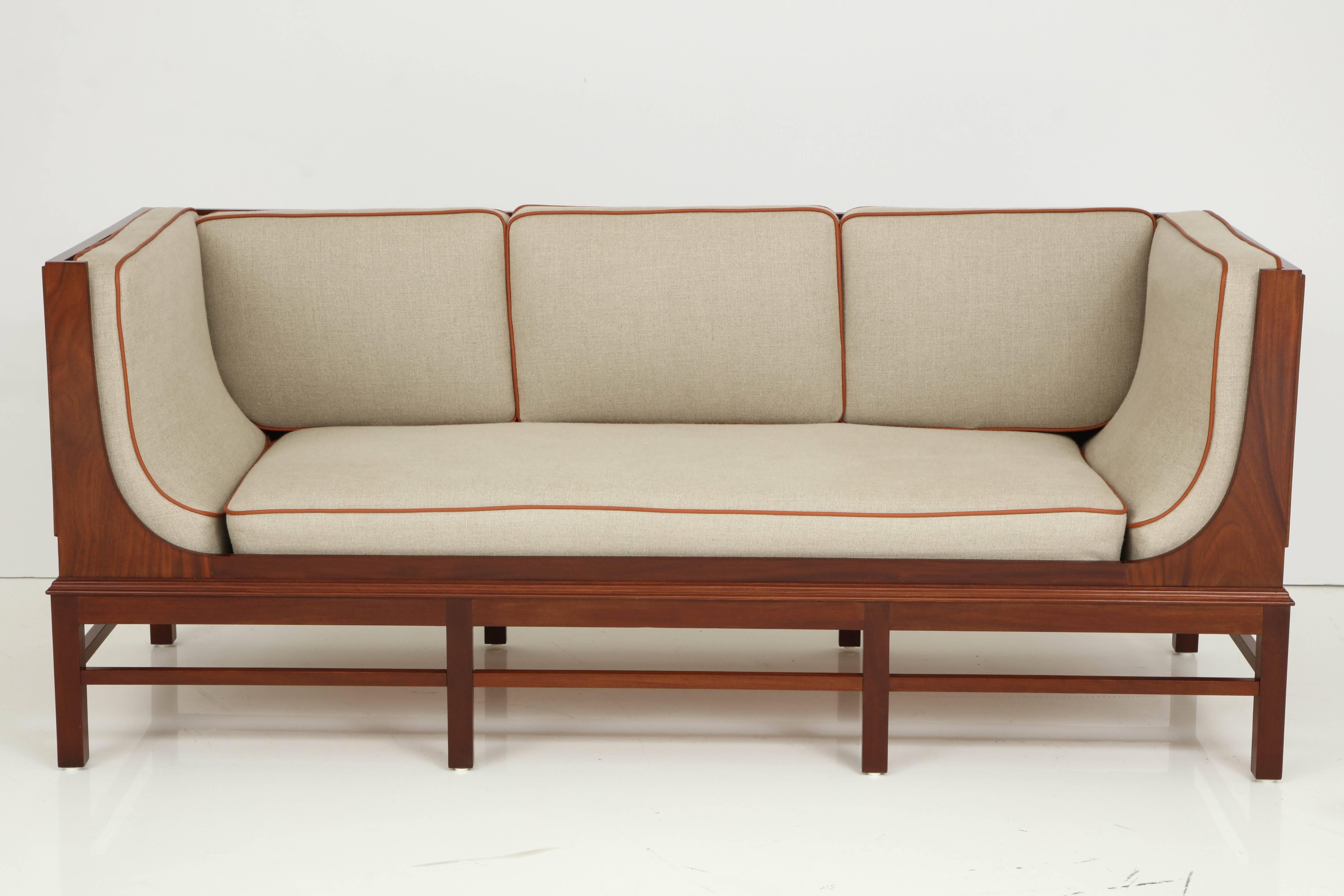 A Danish cabinet maker quality mahogany and upholstered sofa, circa 1940s, with rectangular back and sides, the sides with parquetry work, three loose back seat cushion, curved end cushion conforming to a curved molded frieze, raised on square legs