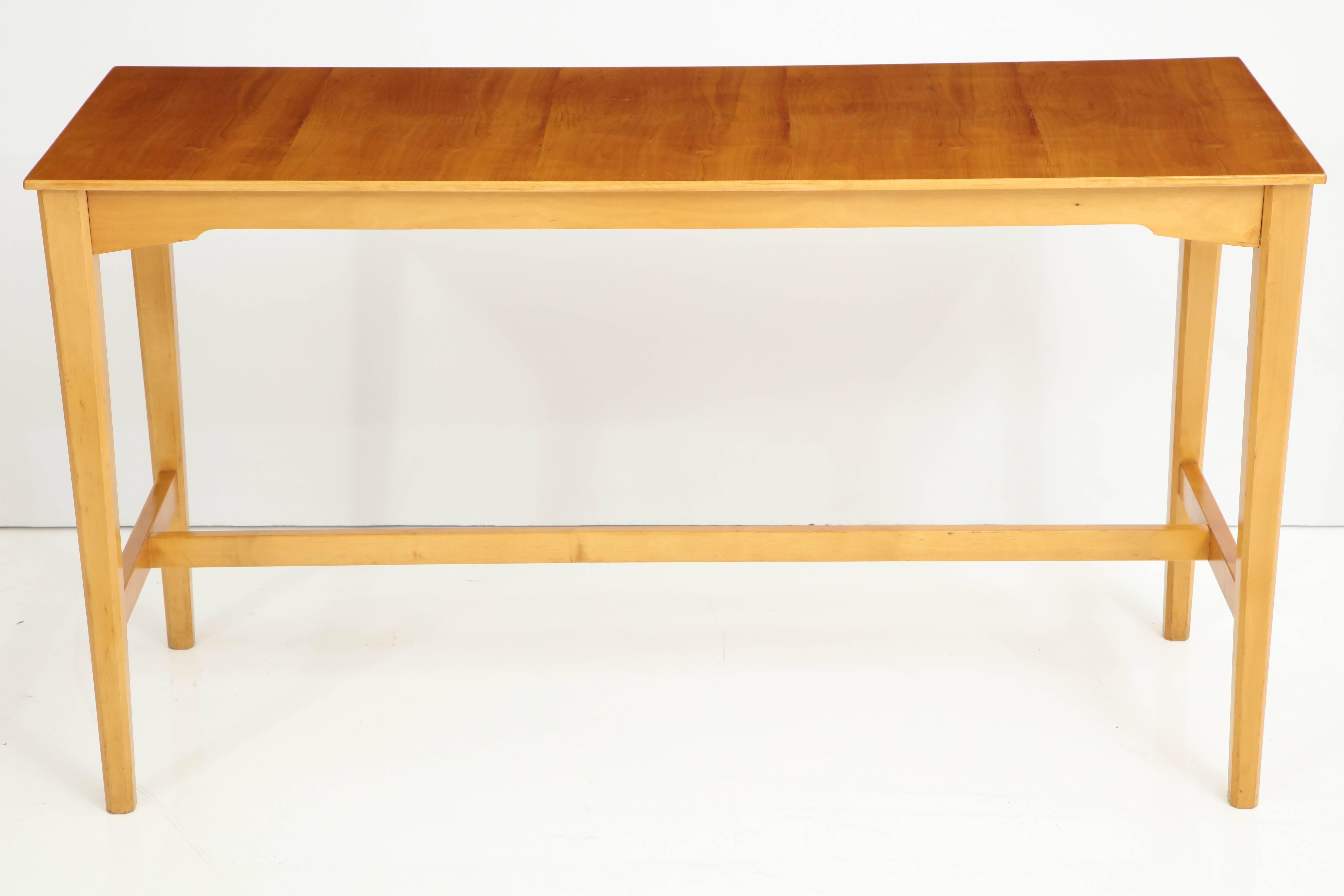 Console suédoise en bois fruitier produite pour NK (Nordiska Kompaniet) vers 1944, de forme rectangulaire avec des pieds coniques carrés reliés par une traverse en forme de H. Etiquette en papier sur la face inférieure. Avec une documentation