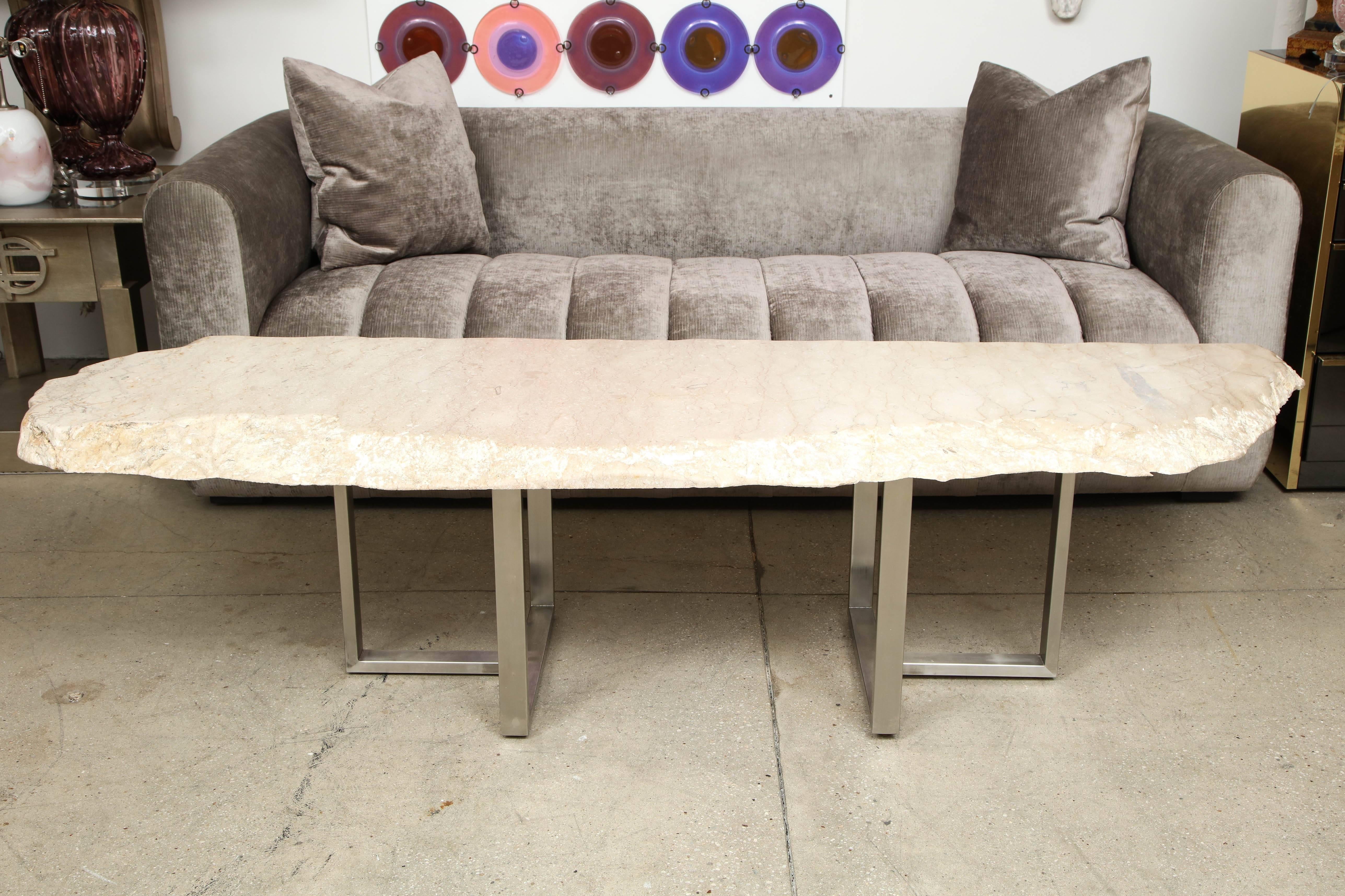 Wonderful large Free form Travertine coffee table.
This spectacular piece of two inch thick Travertine with a raw edge has a slight polished sealed finish and is supported by two steel satin Nickel finished bases.