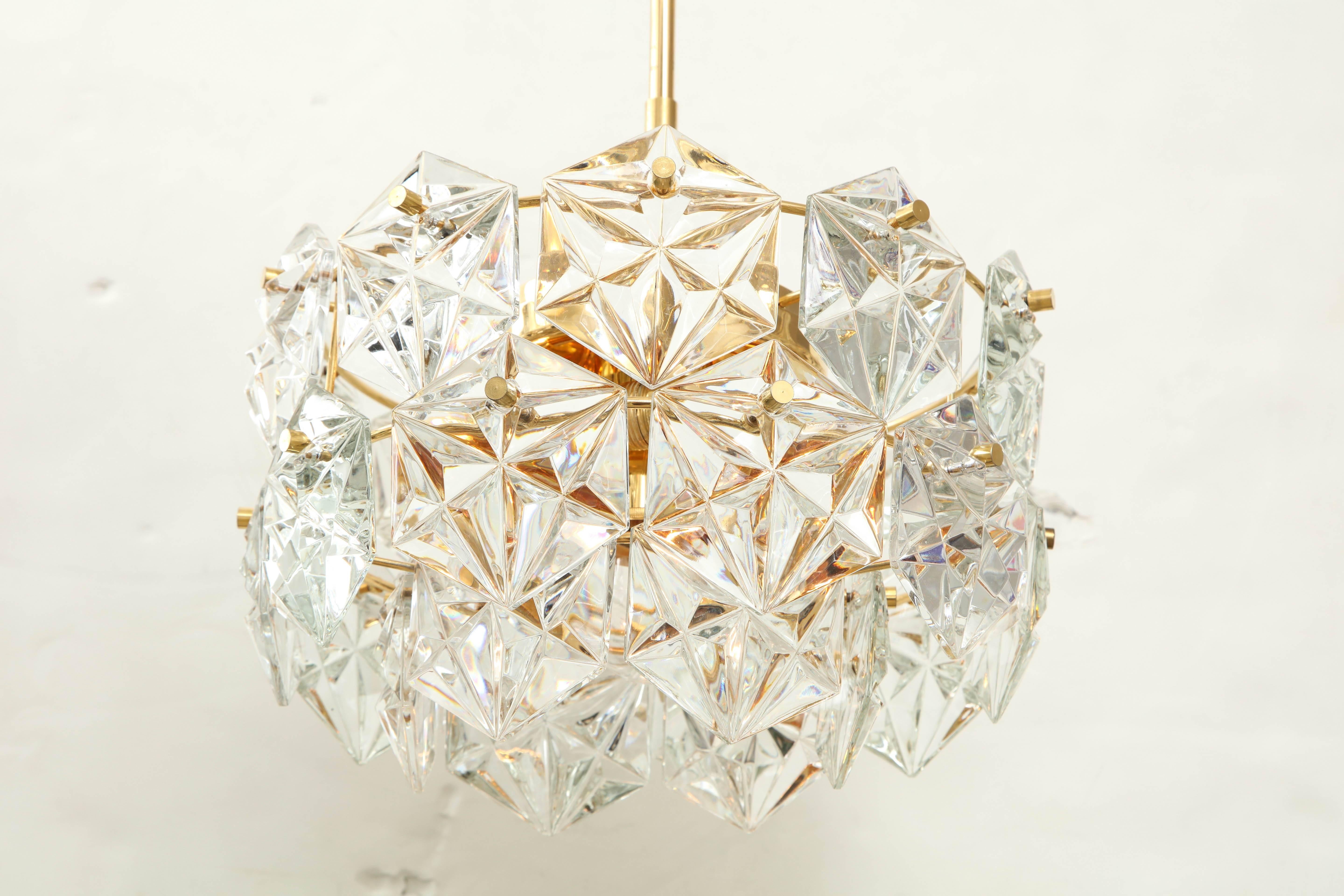 Elegant three-tiered faceted crystal chandelier by Kinkeldey.
The 22-karat gold-plated fixture supports three rings of Hexagonal faceted crystal prisms that glisten when illuminated.
The fixture has been newly rewired and comes complete with a 12
