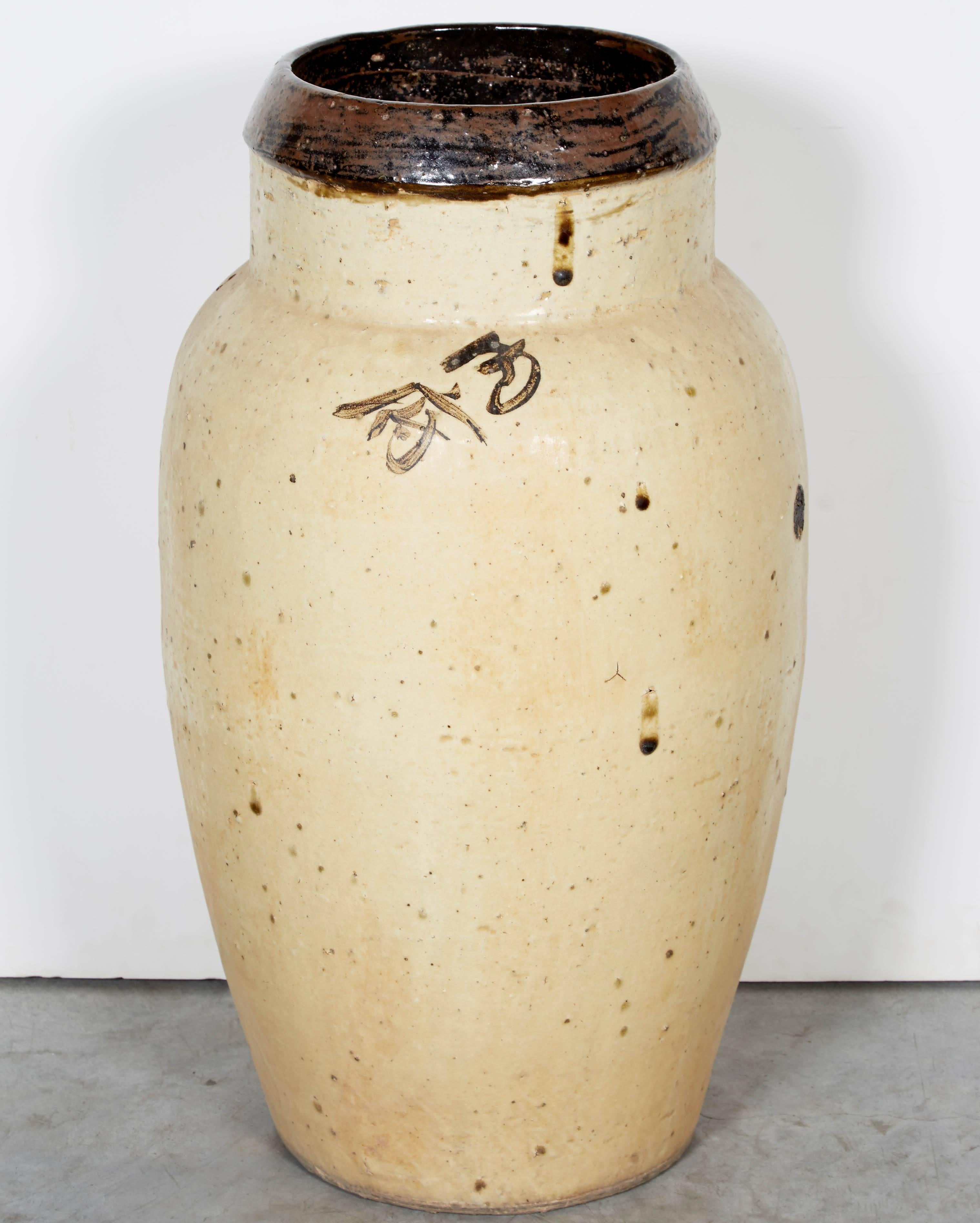 19th century wide mouth ceramic wine jar with dark lip, beautifully glazed off-white body and striking Chinese characters. From Shanxi province, circa 1850. 
CR725.