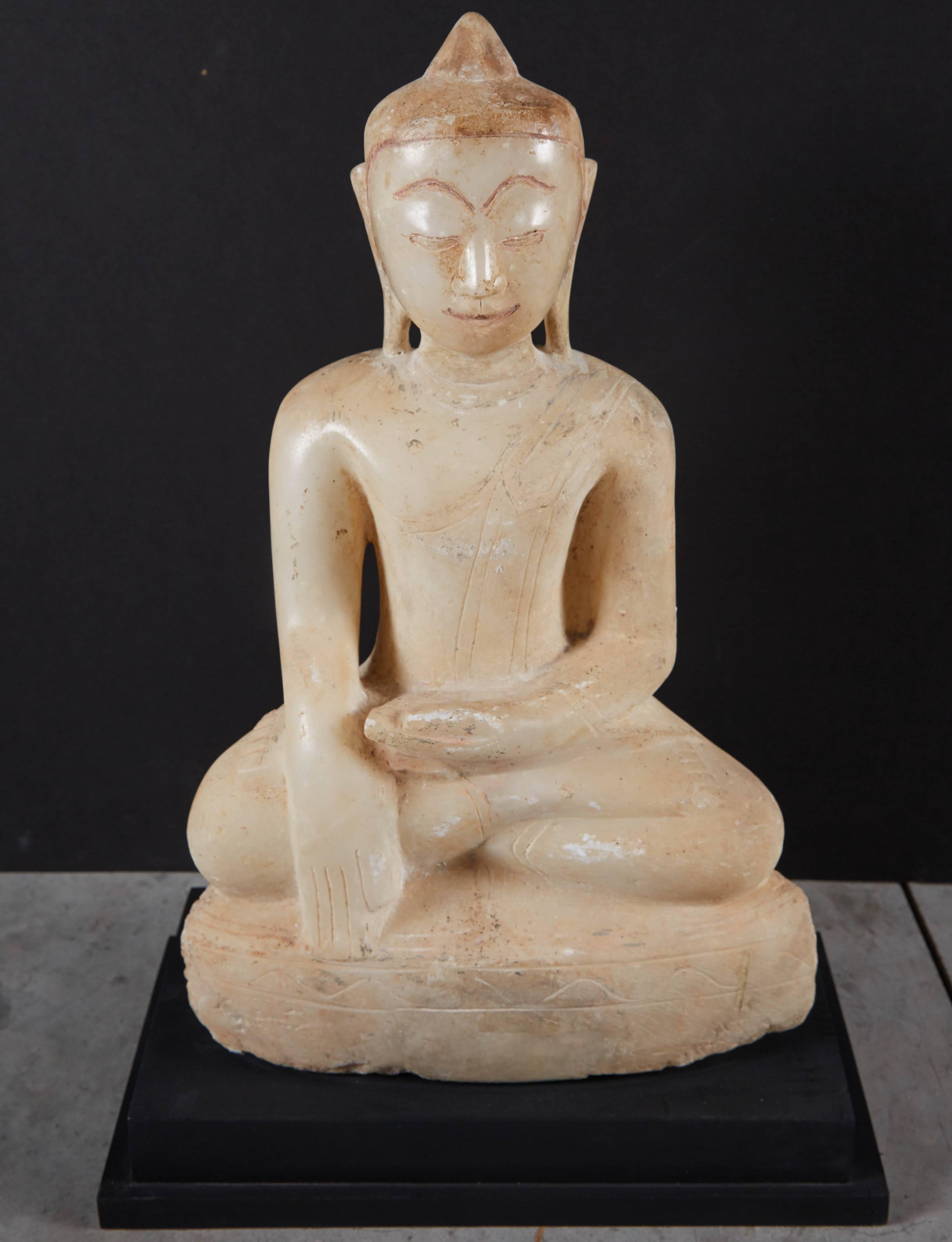 A beautifully carved Burmese Shan style alabaster Buddha with the sweetest smile and a calming, spiritual presence. This early 19th piece is in the Bhumisparsa mudra position (“calling the earth to witness”) and mounted on a custom base.