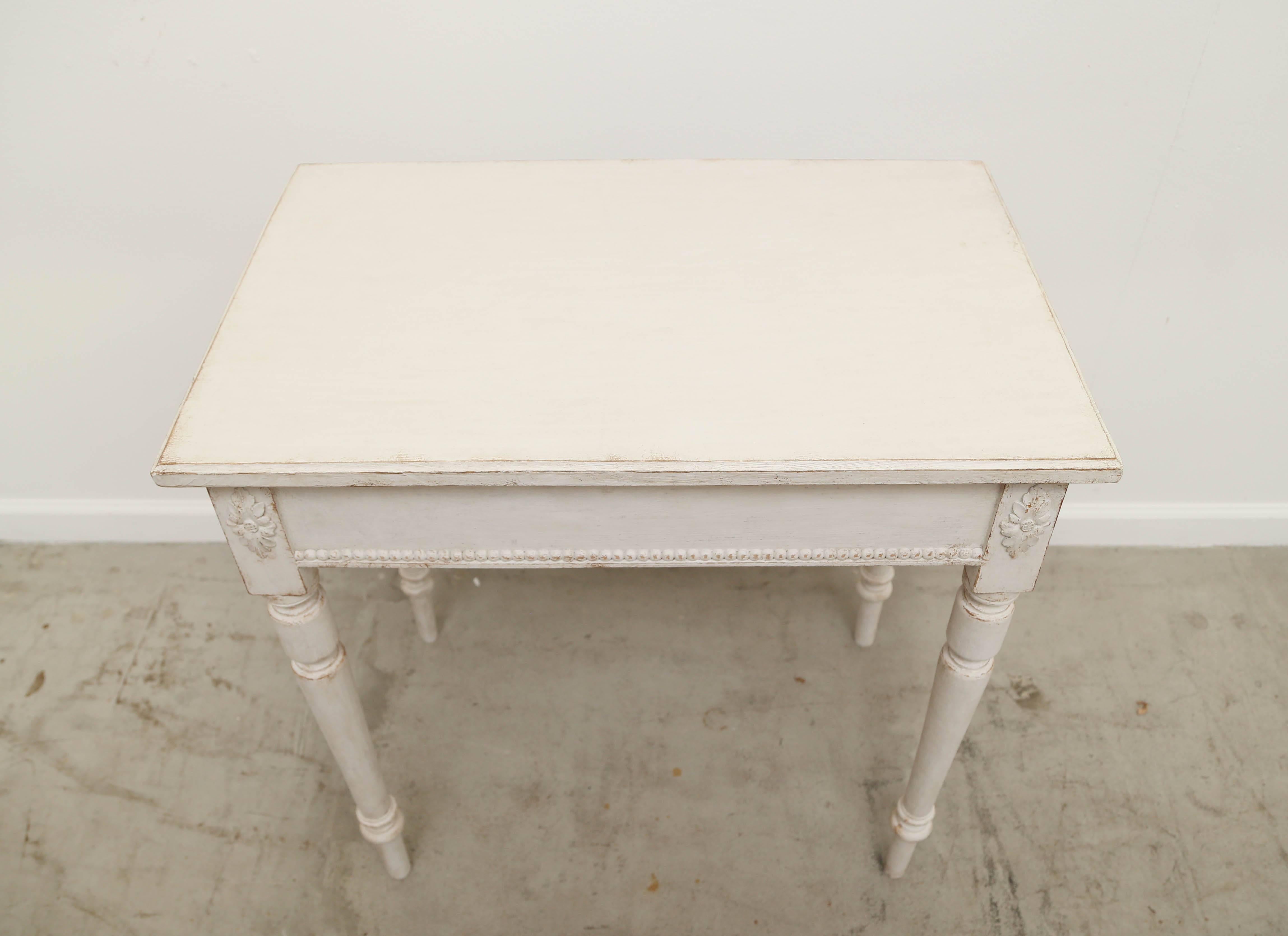 Pair of Swedish antique painted side tables 19th century with pearl beaded apron and rounded fluted legs with a flower rosette. Refreshed paint in Gustavian ivory/ white finish.

Measures: H 30.5'', W 29.75'', D: 19''.
 