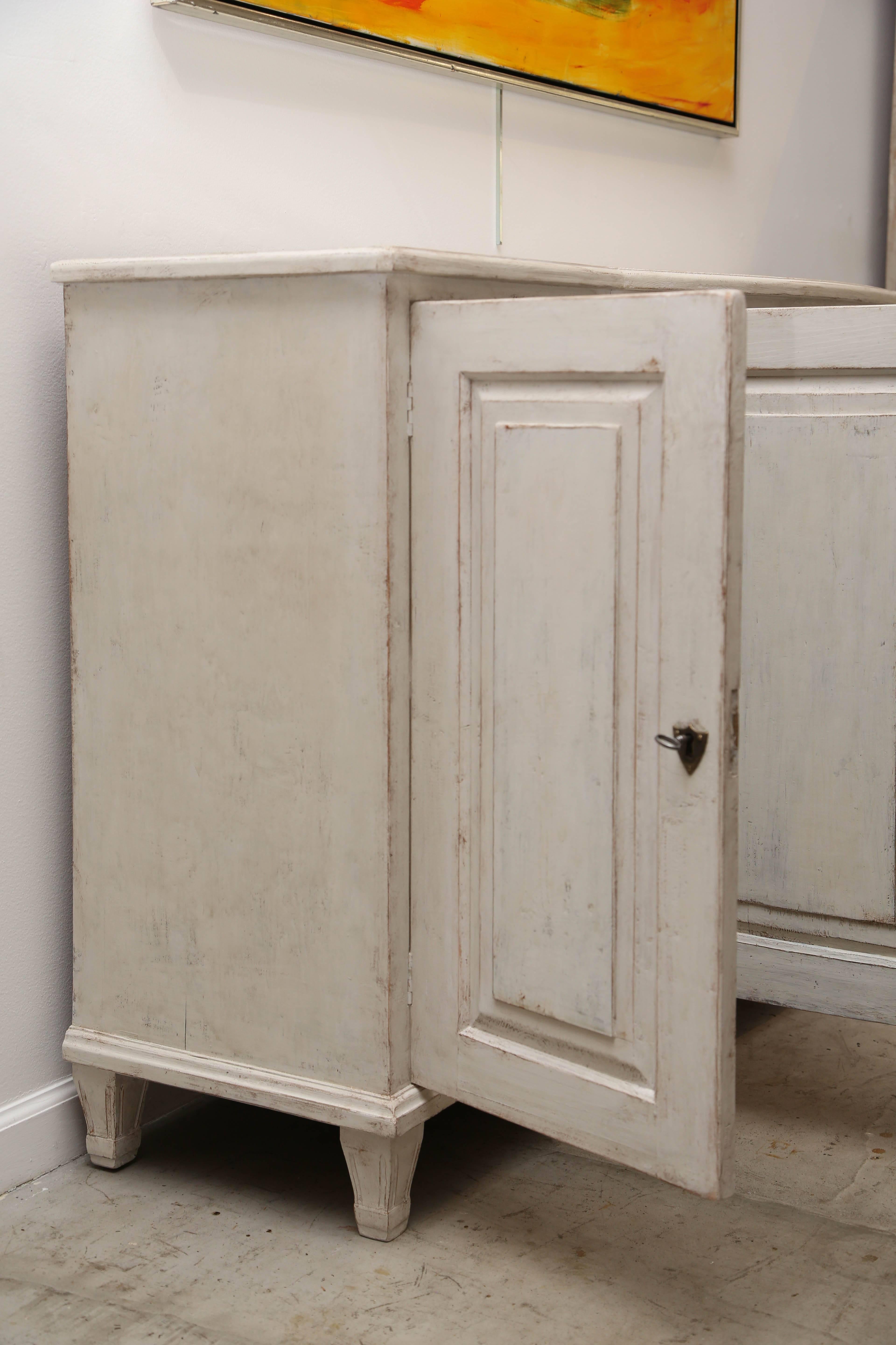 Unusually large antique Swedish Gustavian style painted bowed sideboard 19th century with four raised panel doors and seven small fluted legs. The centre doors are rounded with a rounded edge top.

Refreshed in a white/ivory  distressed Gustavian
