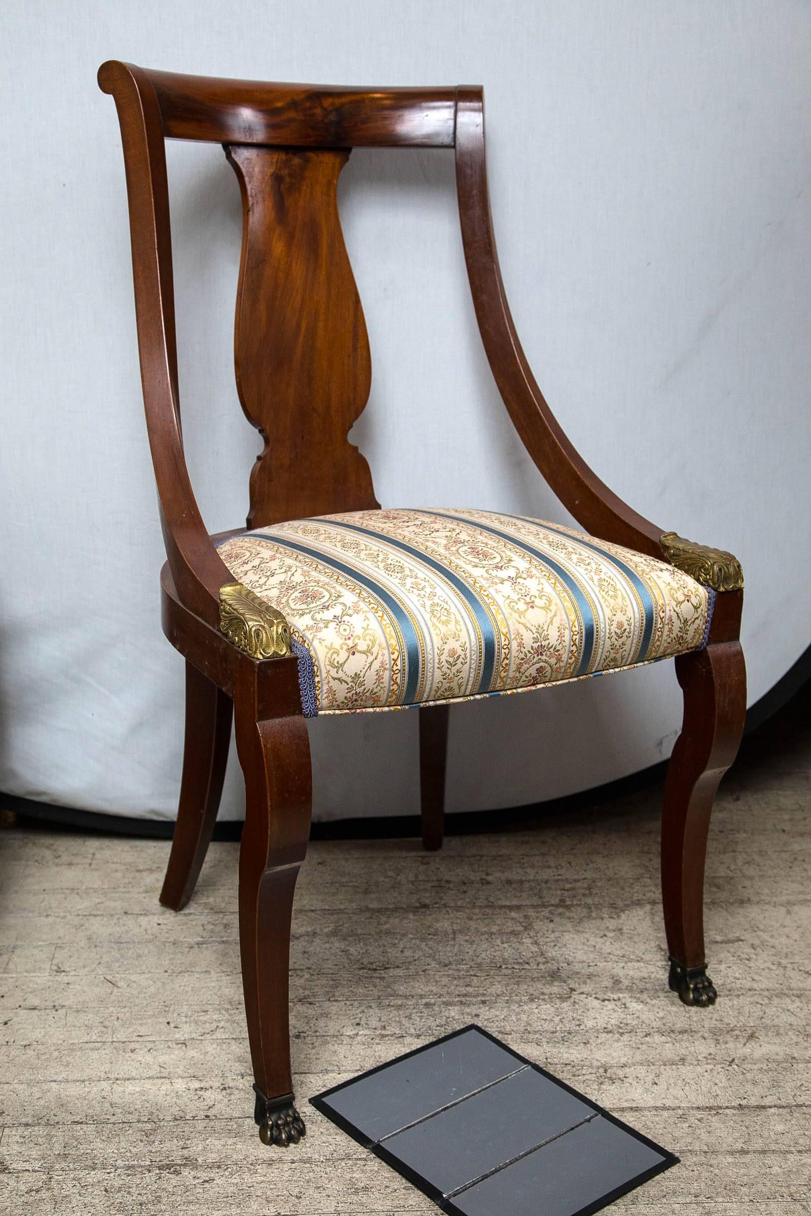 Made of mahogany and in the gondola form popular in the Empire period of the early 19th century. Shaped back splat, paw feet and gilt highlights at the terminus of the arms.
The back tapers from 15 inches wide at the top to 17.5 at the seat. The