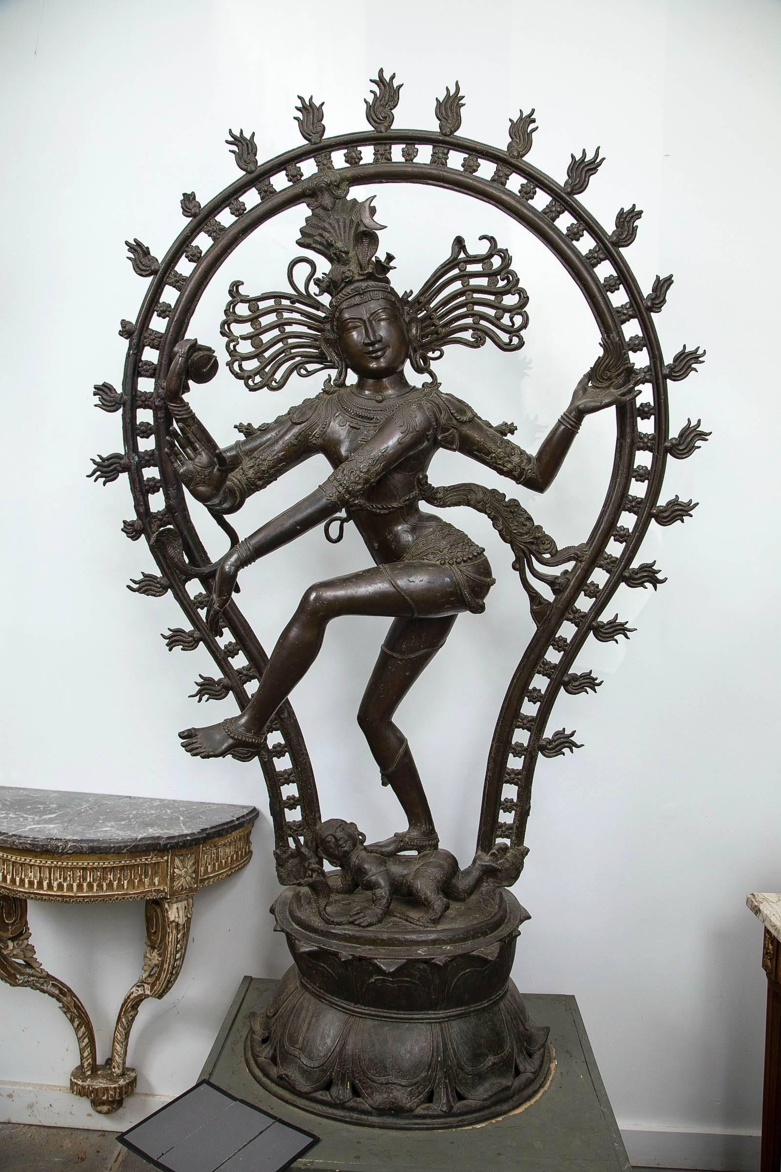 Shiva stands on a lotus base. Below his raised left leg is the dwarf Apasmara. A cobra can be seen on the left side of the aureole of flames and upon Shiva's head.
Brown patina.
 