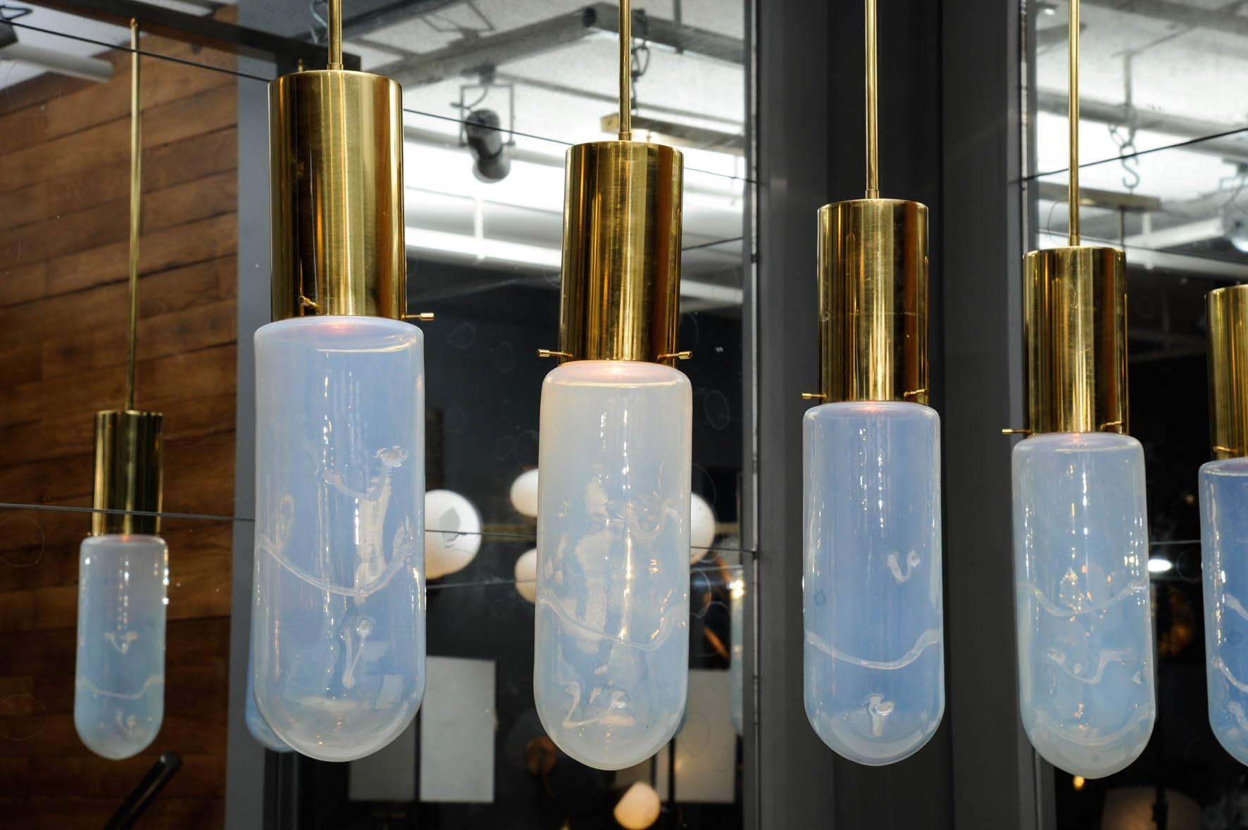 Leucos suspension my of a brass structure and five pendants end by a tinted glass piece.