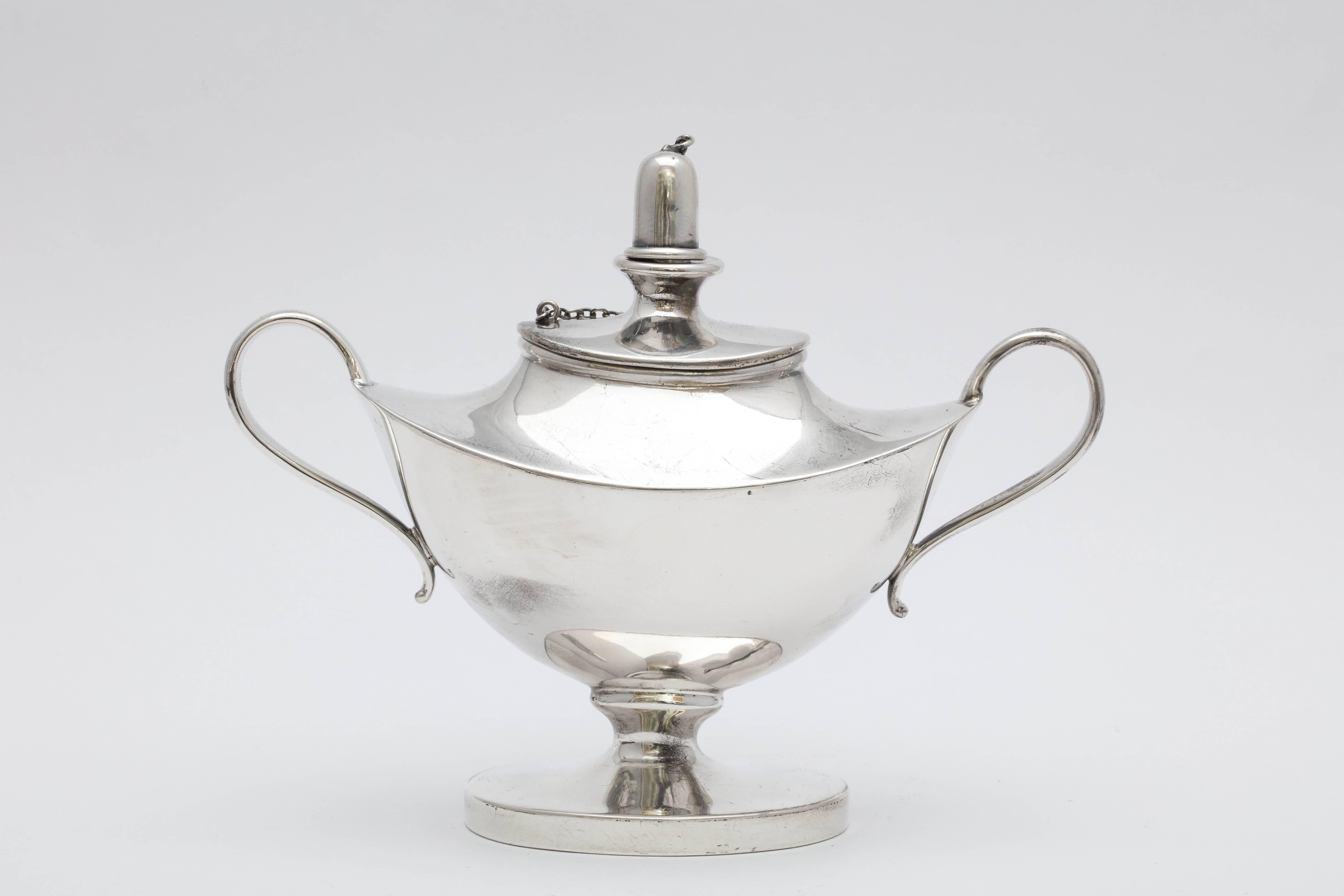 Edwardian, sterling silver, Aladdin's lamp-style table oil lamp or lighter, American, circa 1920s. Measures: 4 inches high (at highest point) x 5 inches across from handle to handle x 2 inches deep at deepest point. Weighs 3.930 troy ounces. Oval