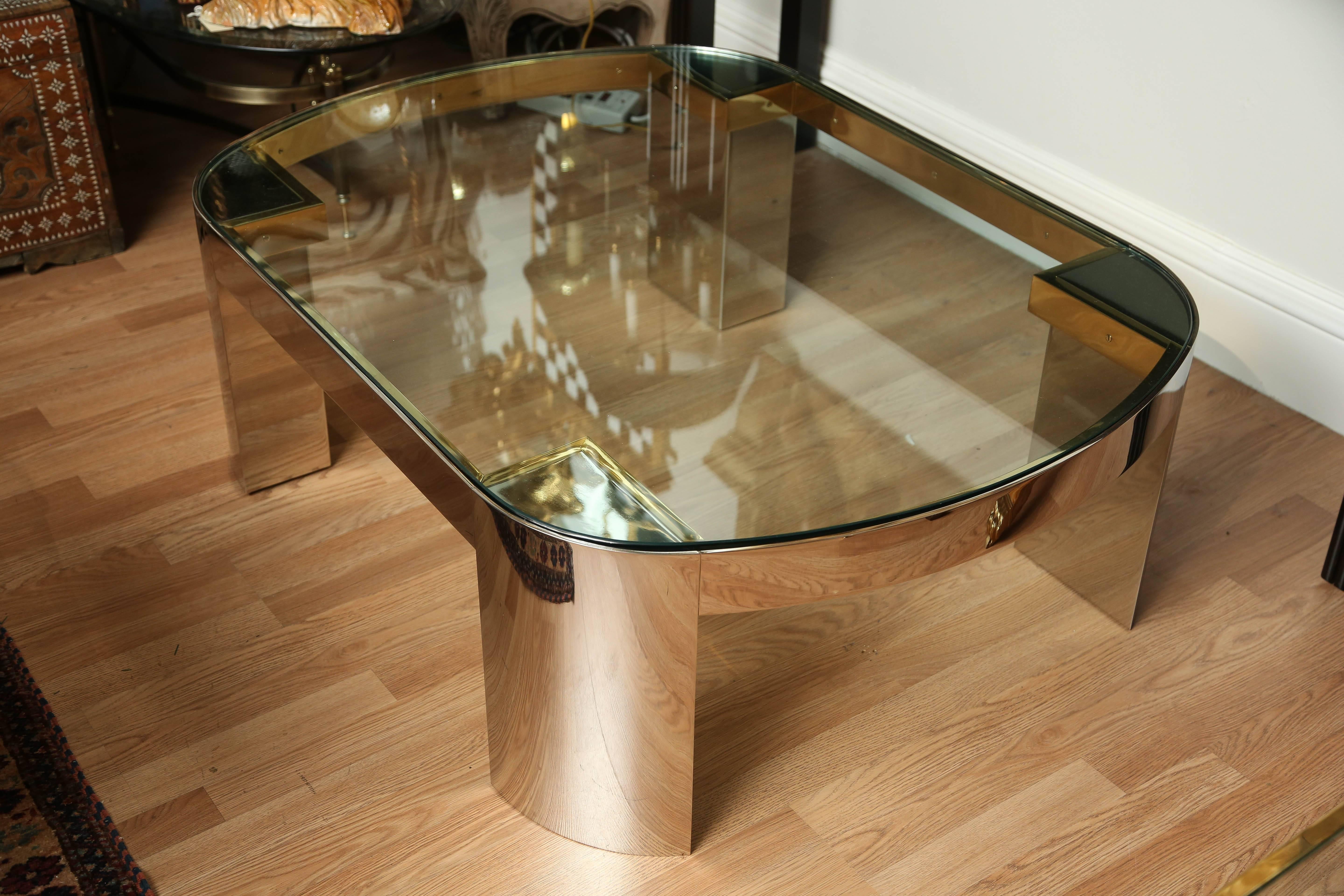 Stunning stainless steel and brass cocktail table with thick glass top by Karl Springer.