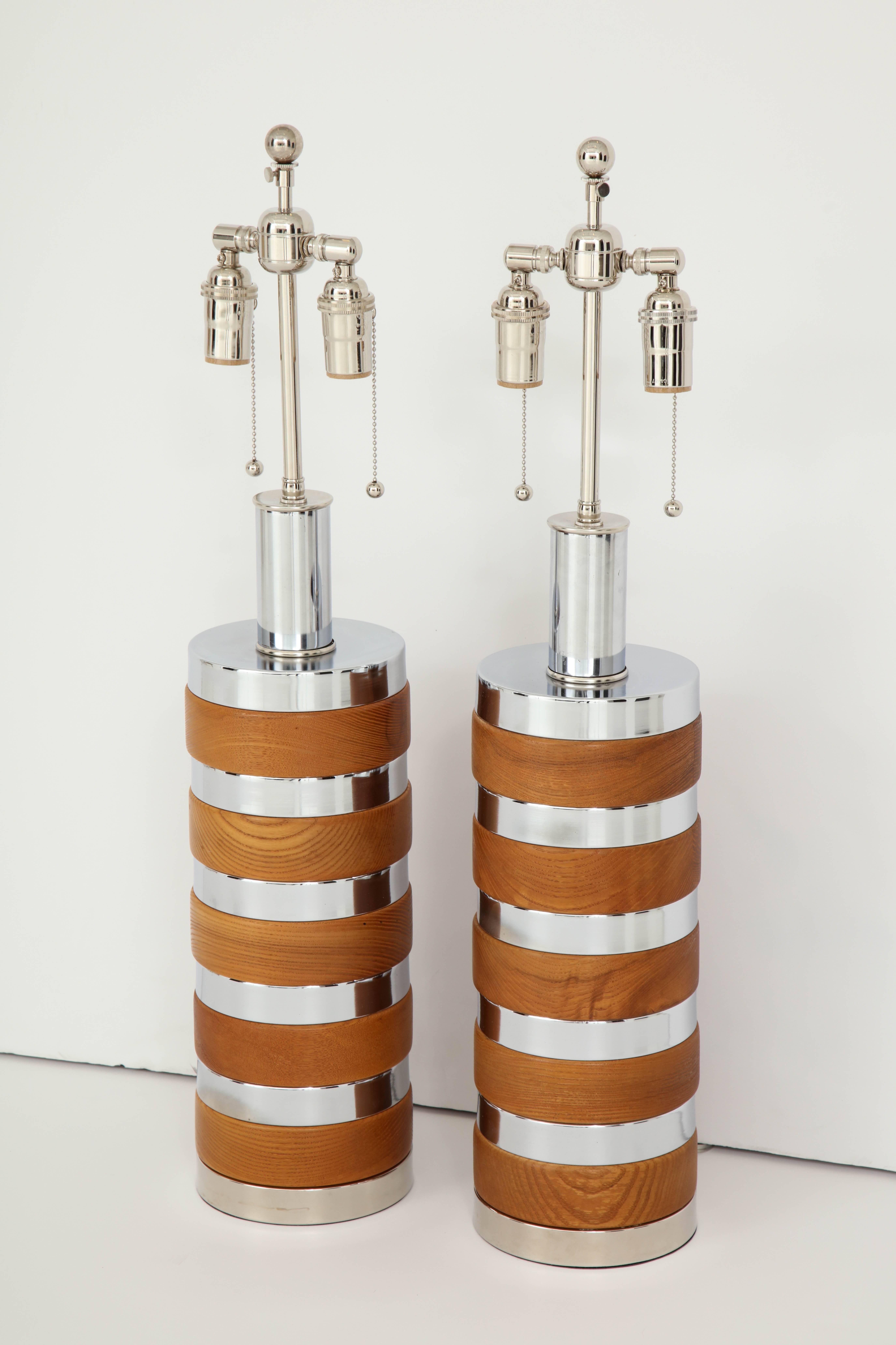 Large pair of cylindrical chrome and wood lamps by Laurel Lamp company.
The lamps have alternating discs of wood and chrome and they have been newly rewired with polished chrome double clusters that take standard light bulbs.