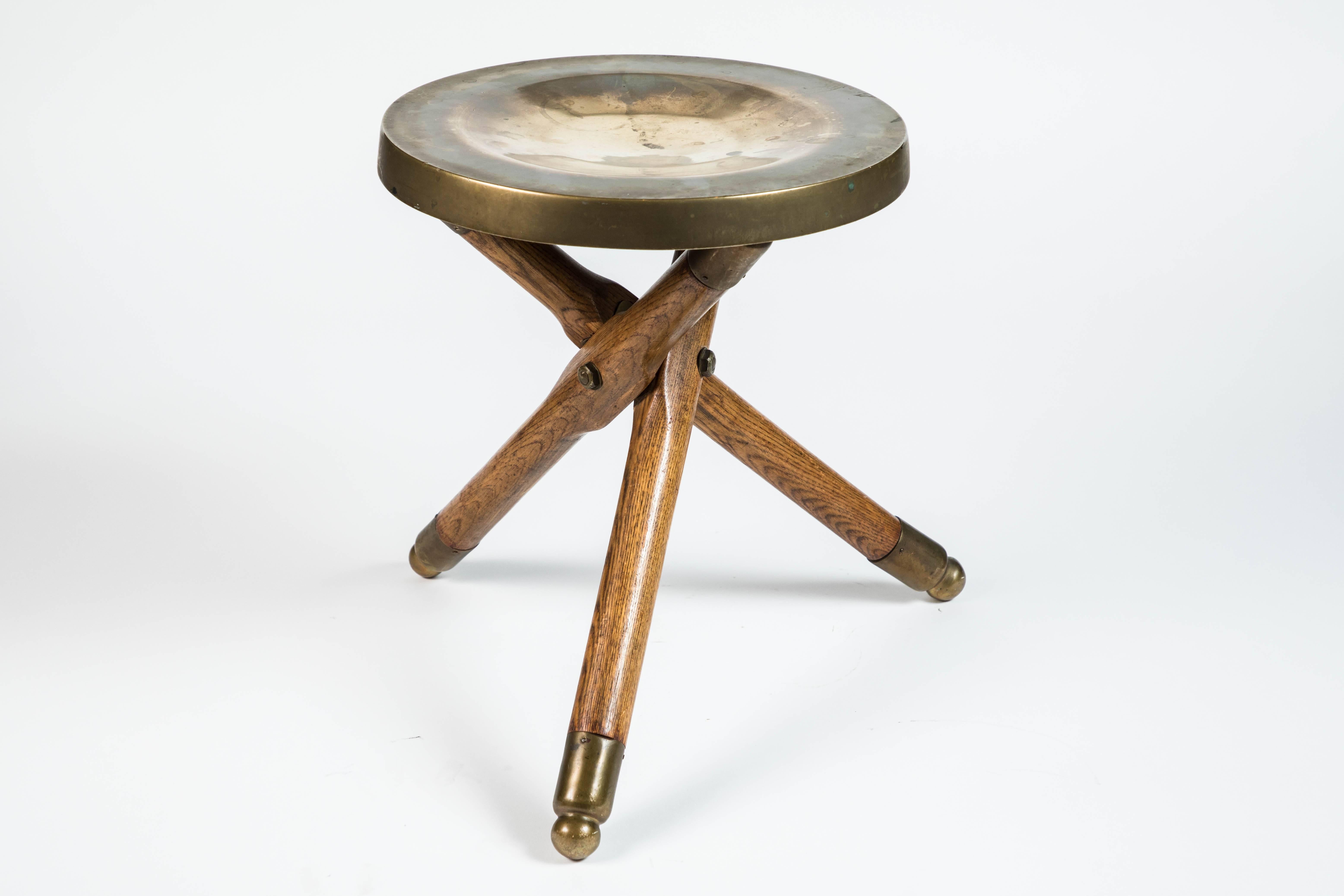 Vintage wooden tripod folding stool with brass seat and brass feet.