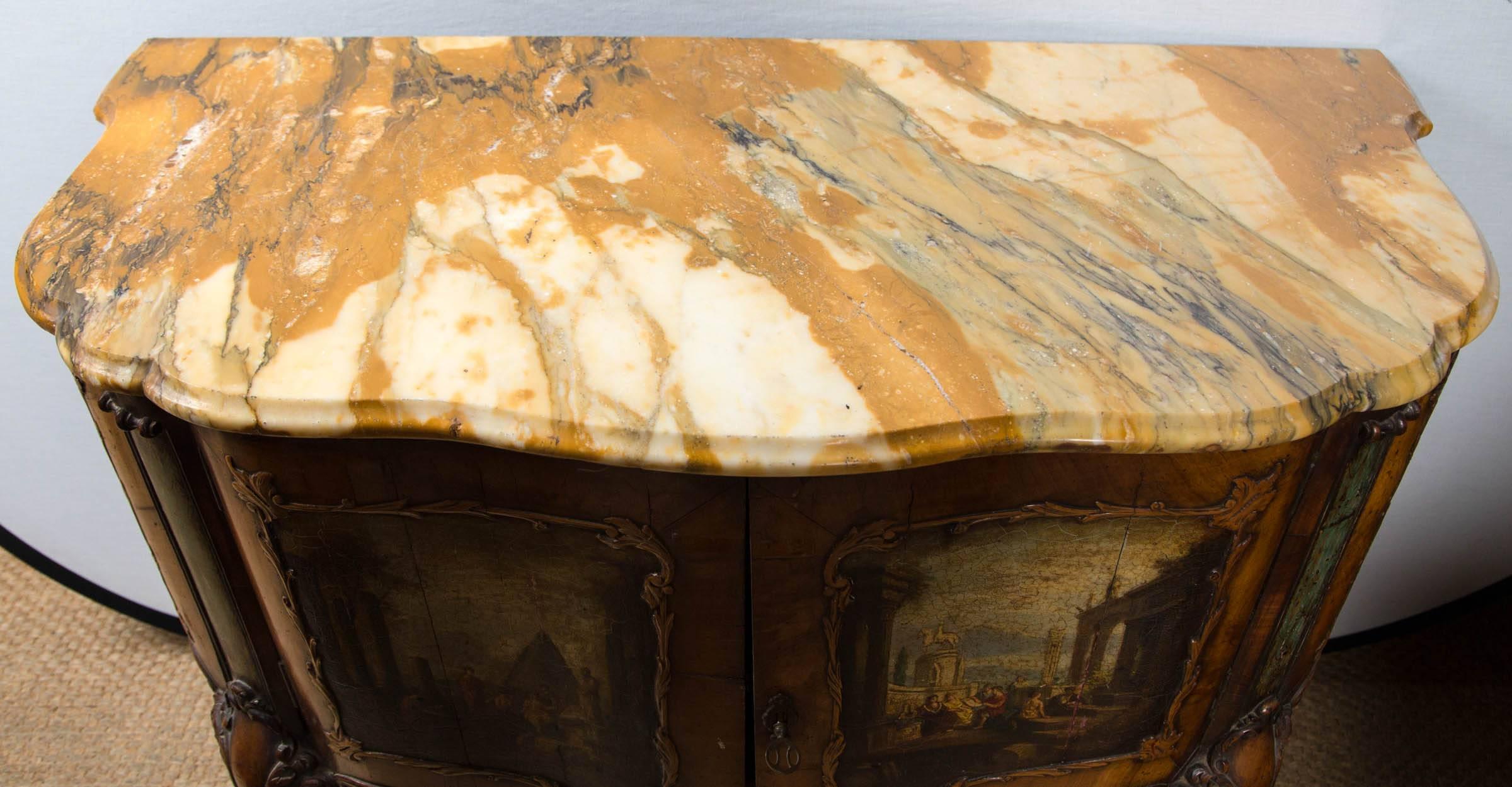 This  commode is painted  with neo-classical scenes, probably inspired  by the engravings of  Panini.  The front is a double door  cabinet  that opens to the entire  interior.  The marble top is inset.  Cabriole legs   ending in scrolled  pad feet.