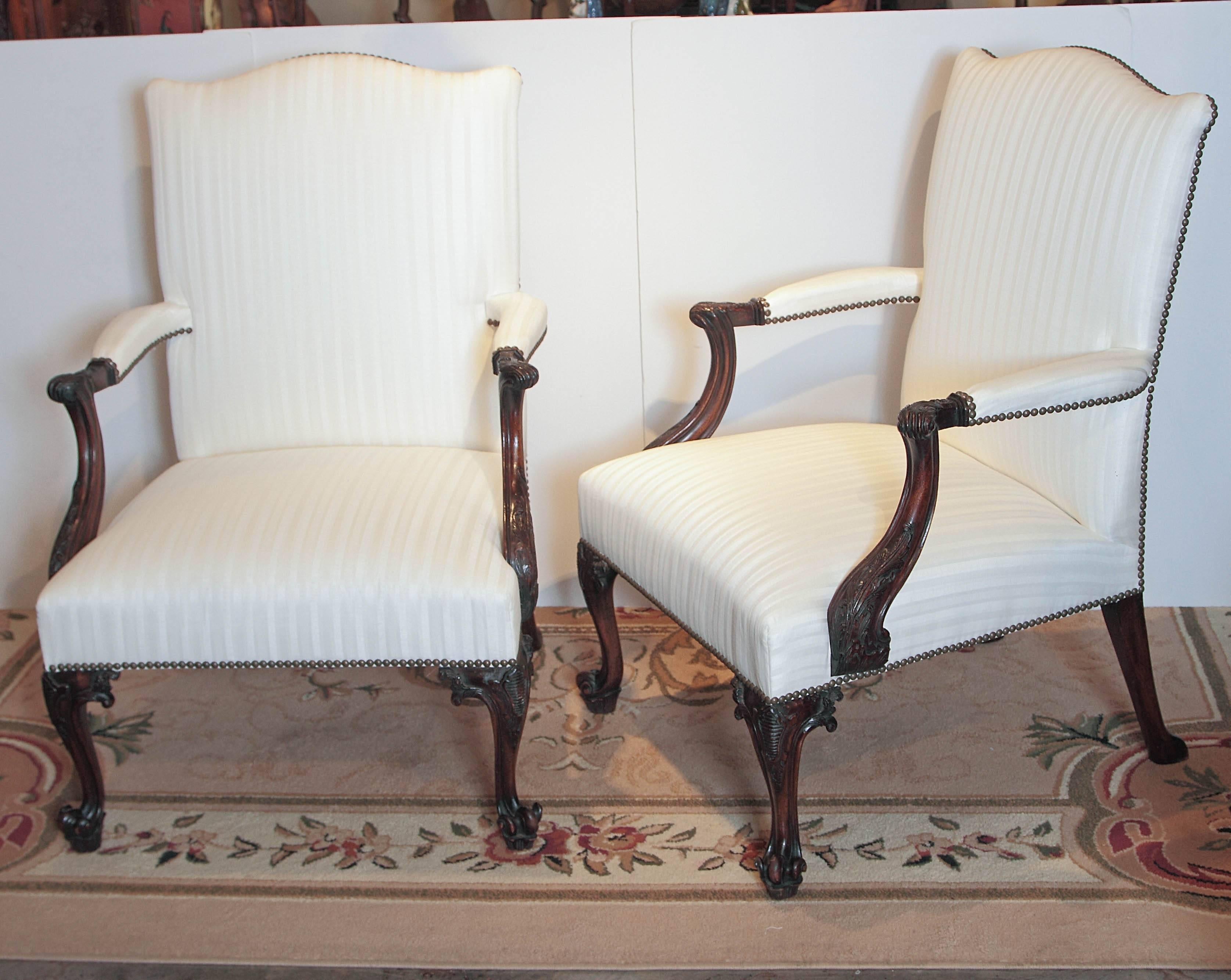 Pair of 19th century English Georgian mahogany hand-carved armchairs. Beautiful deep hand carving with a nice aged mahogany patina. Covered in a stripe silk.