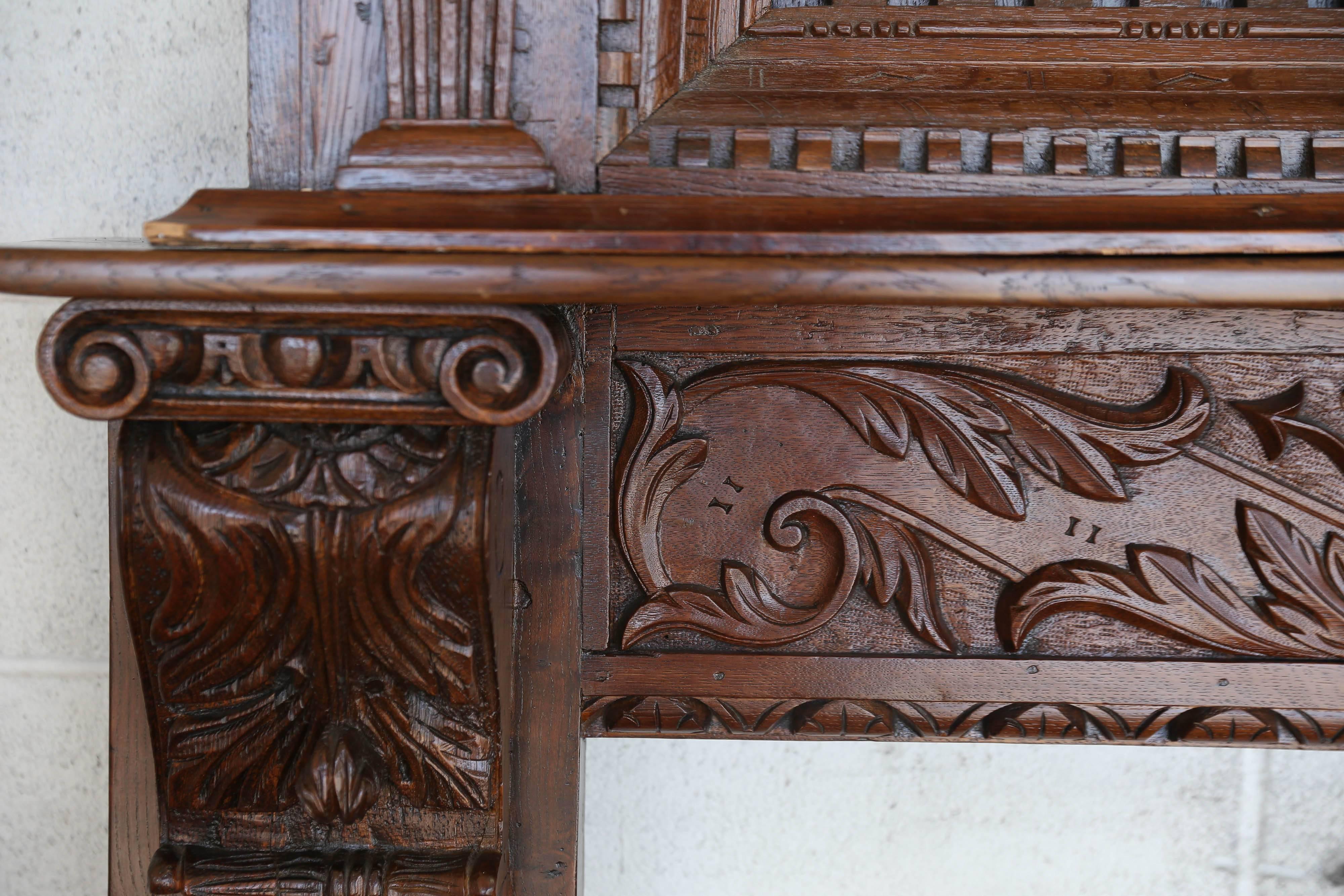 Elaborately carved English oak fireplace surround and over-mantel.
Over Mantel carvings include lion heads, bearded man in center, posts with acanthus leaves,
two more carved figures, & dentil carvings at crown. 

Fireplace Surround Posts mimic